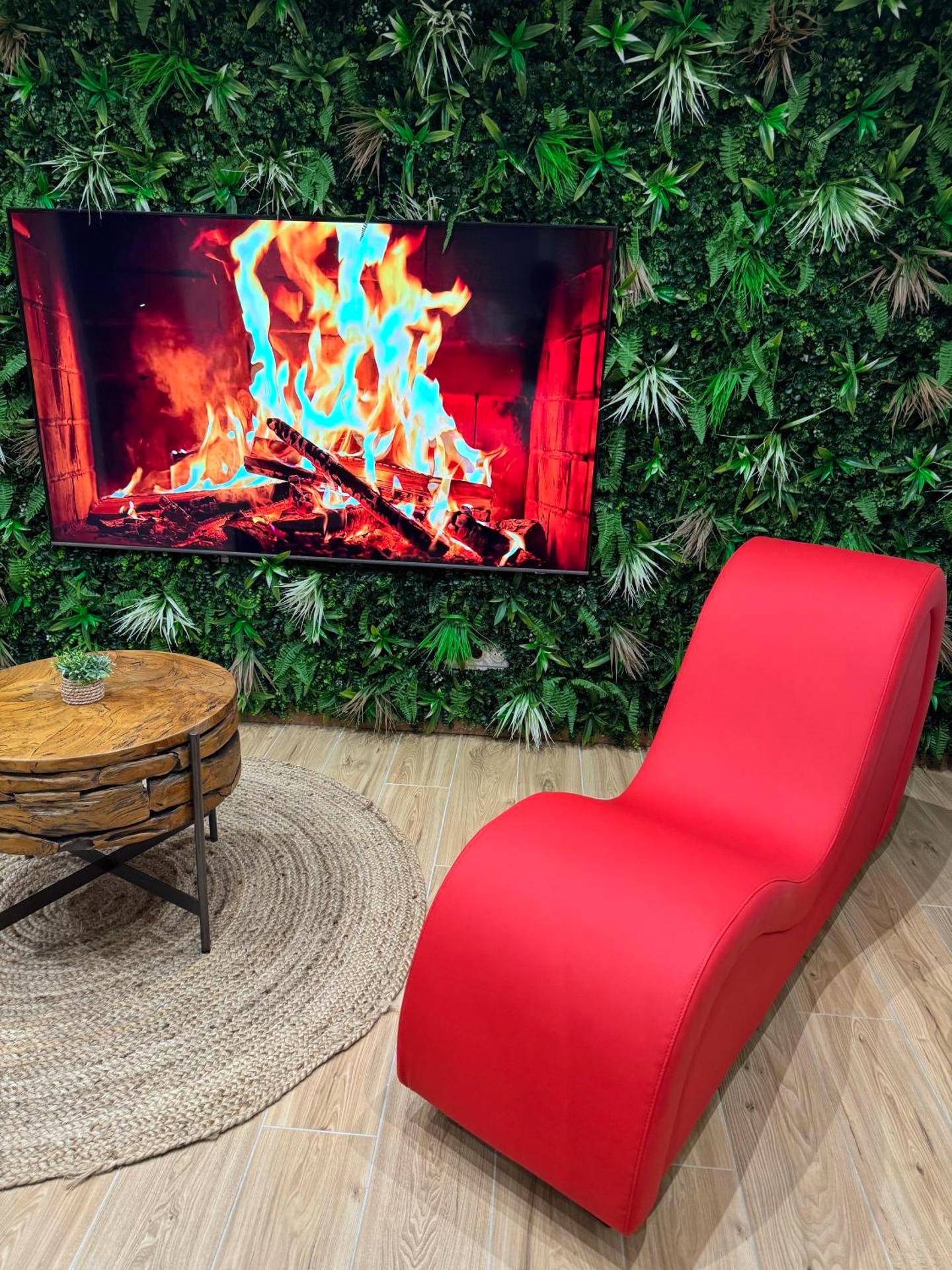 Fauteuil tantra rouge devant un écran cheminée - F & C Love Spa, Sauna and Tantra