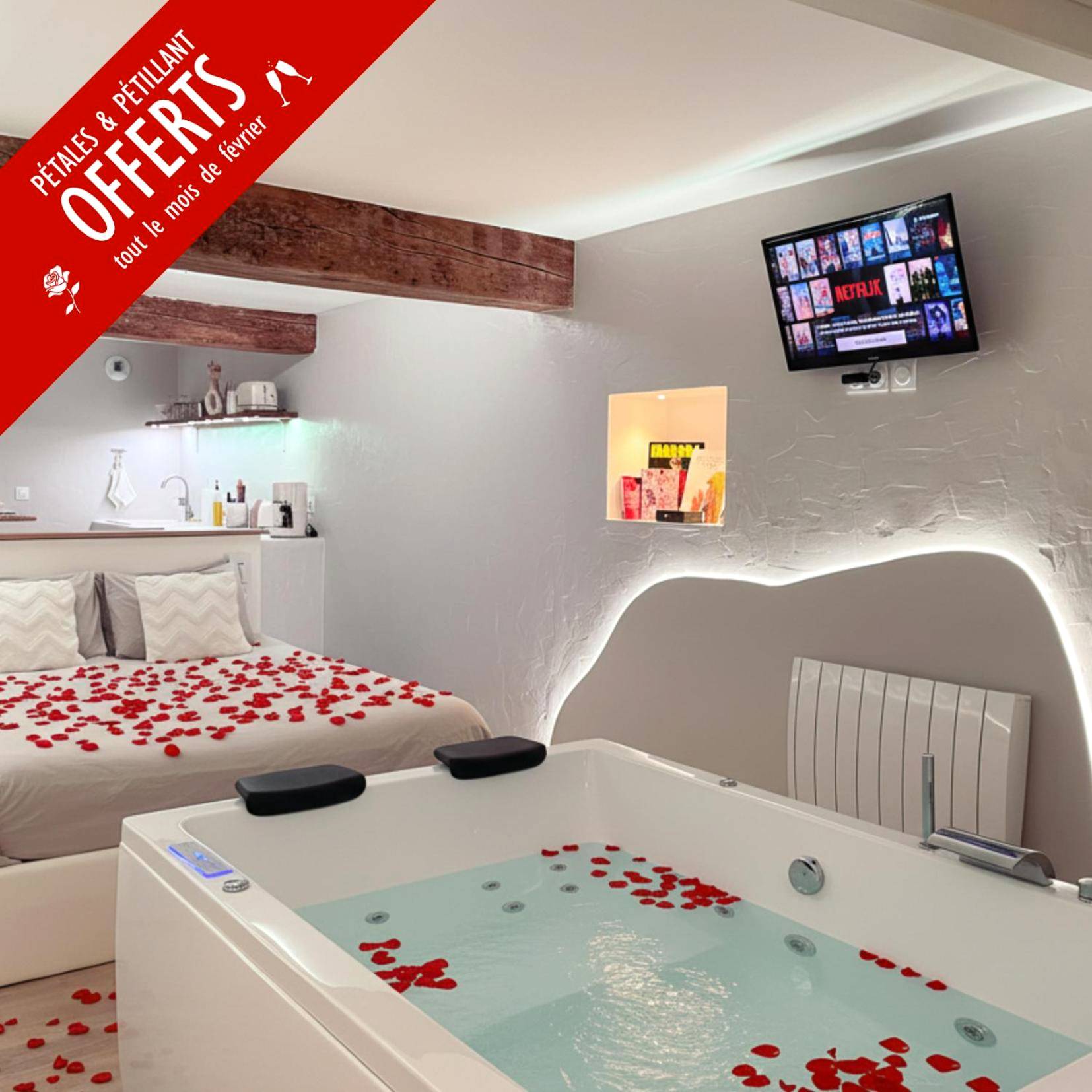 Jacuzzi et lit parsemés de pétales de roses - Love Room Montrevault - À la folie - Loft & Spa