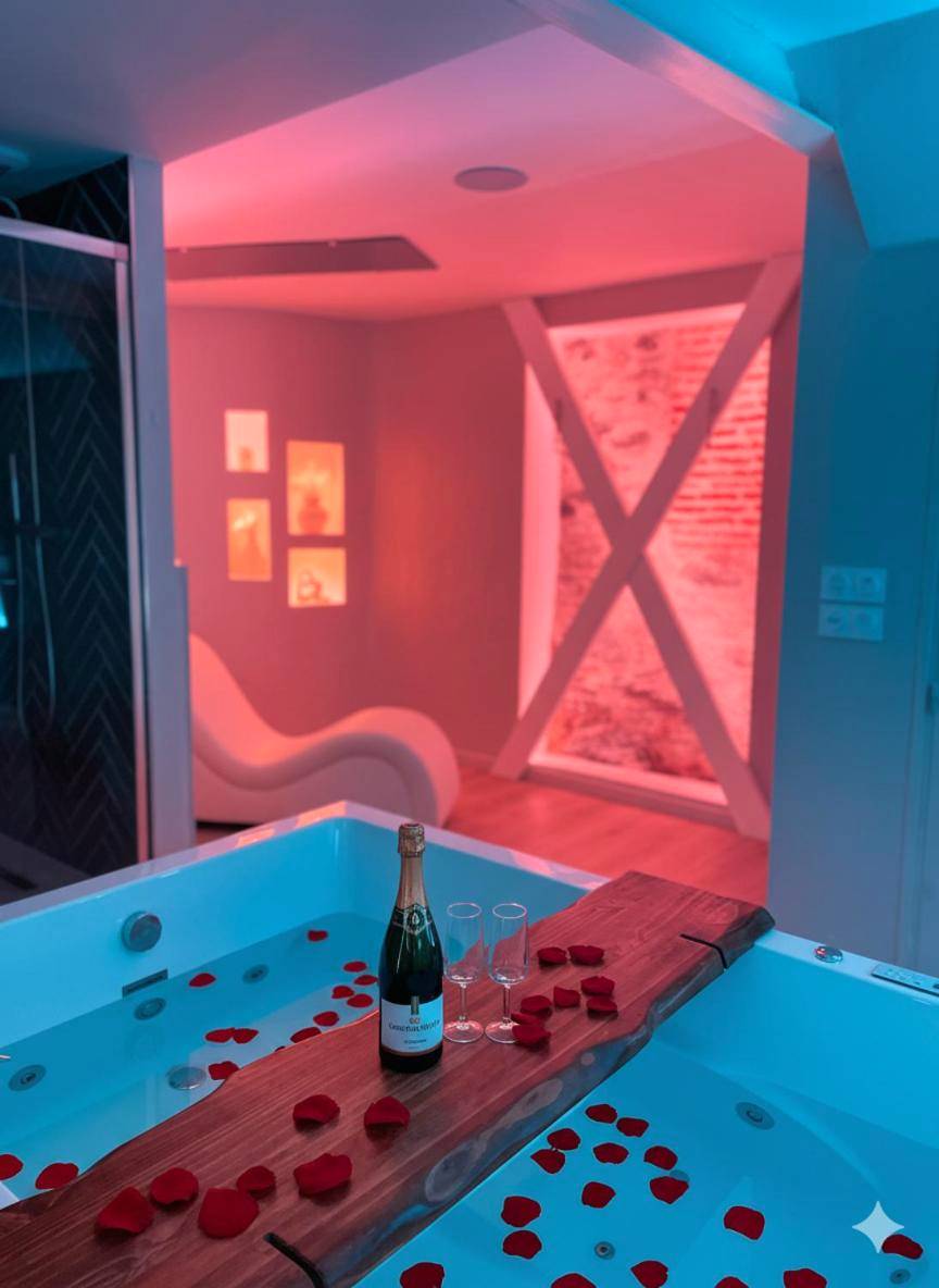 Champagne et pétales sur jacuzzi en lumière rose - À la folie - Loft & Spa