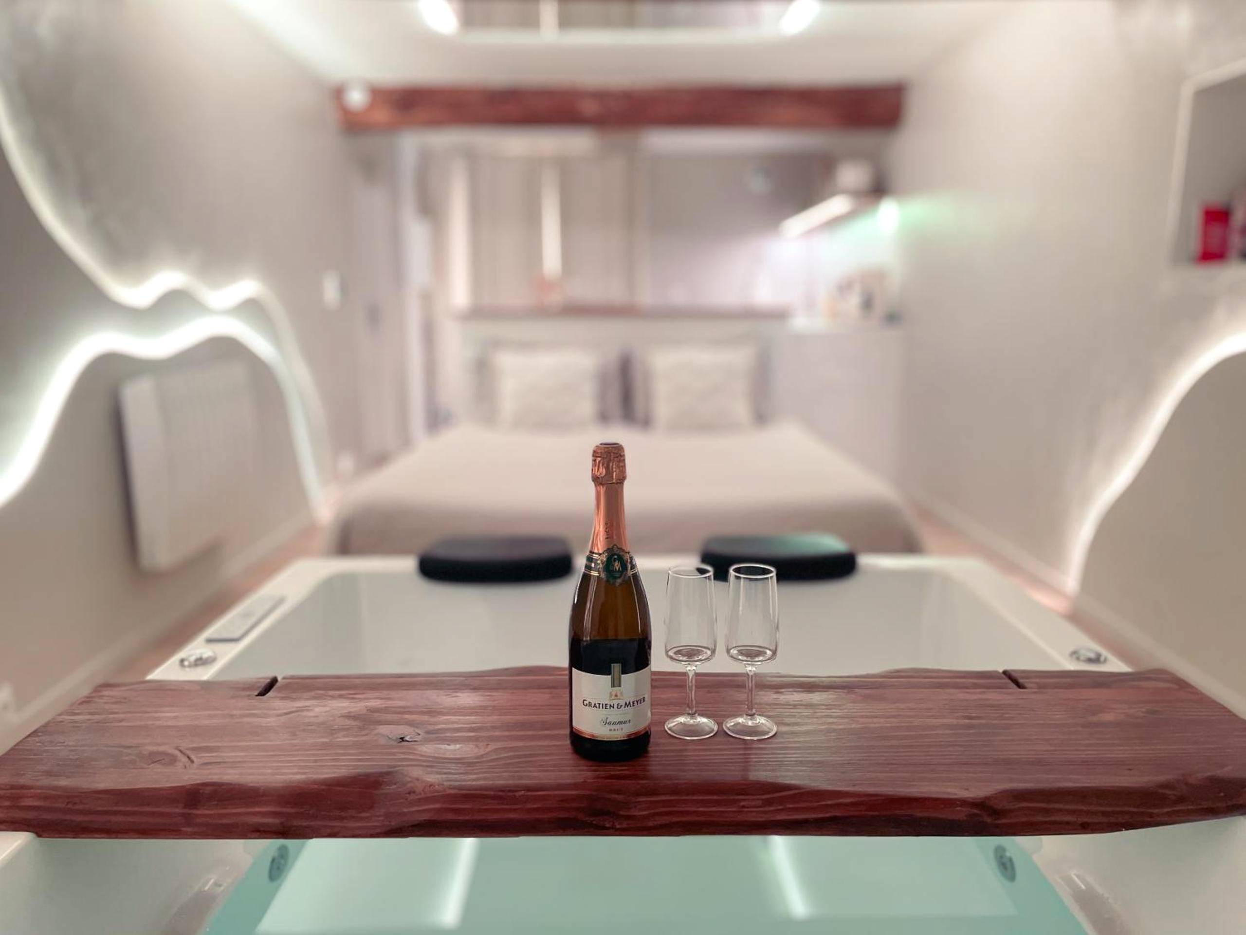 Bouteille de pétillant sur pont de baignoire - À la folie - Loft & Spa