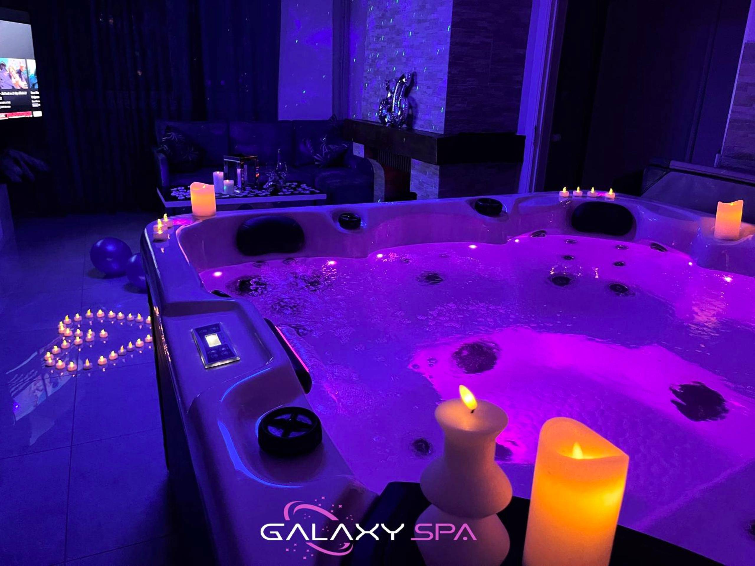 Jacuzzi privatif avec éclairage violet et bougies - Love Room Champigneulles - GALAXY SPA - Suite Neptune Jacuzzi et...