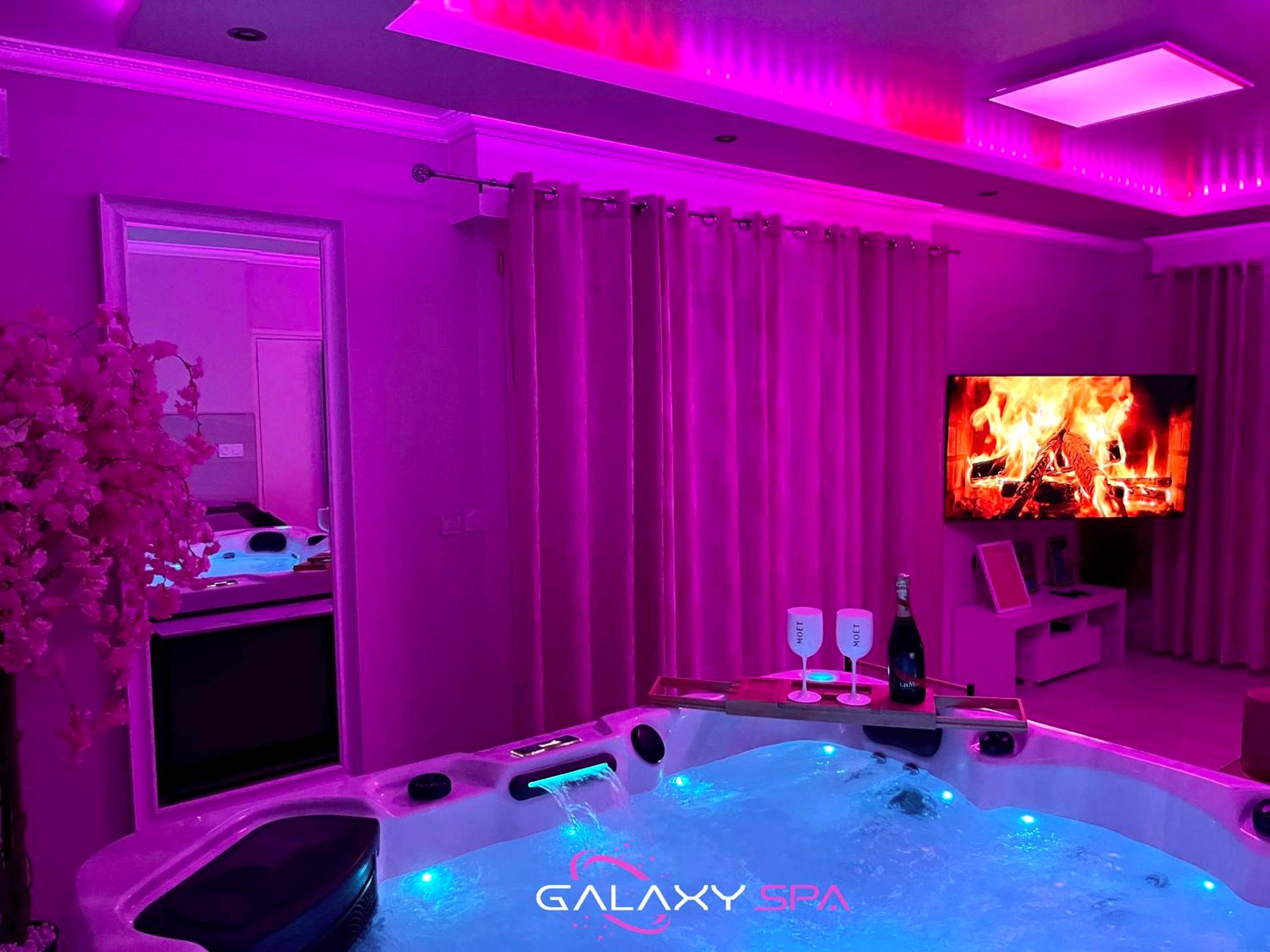 Jacuzzi avec champagne et ambiance néon rose - Love Room Champigneulles - GALAXY SPA - Suite Venus Jacuzzi et Sauna Privatif