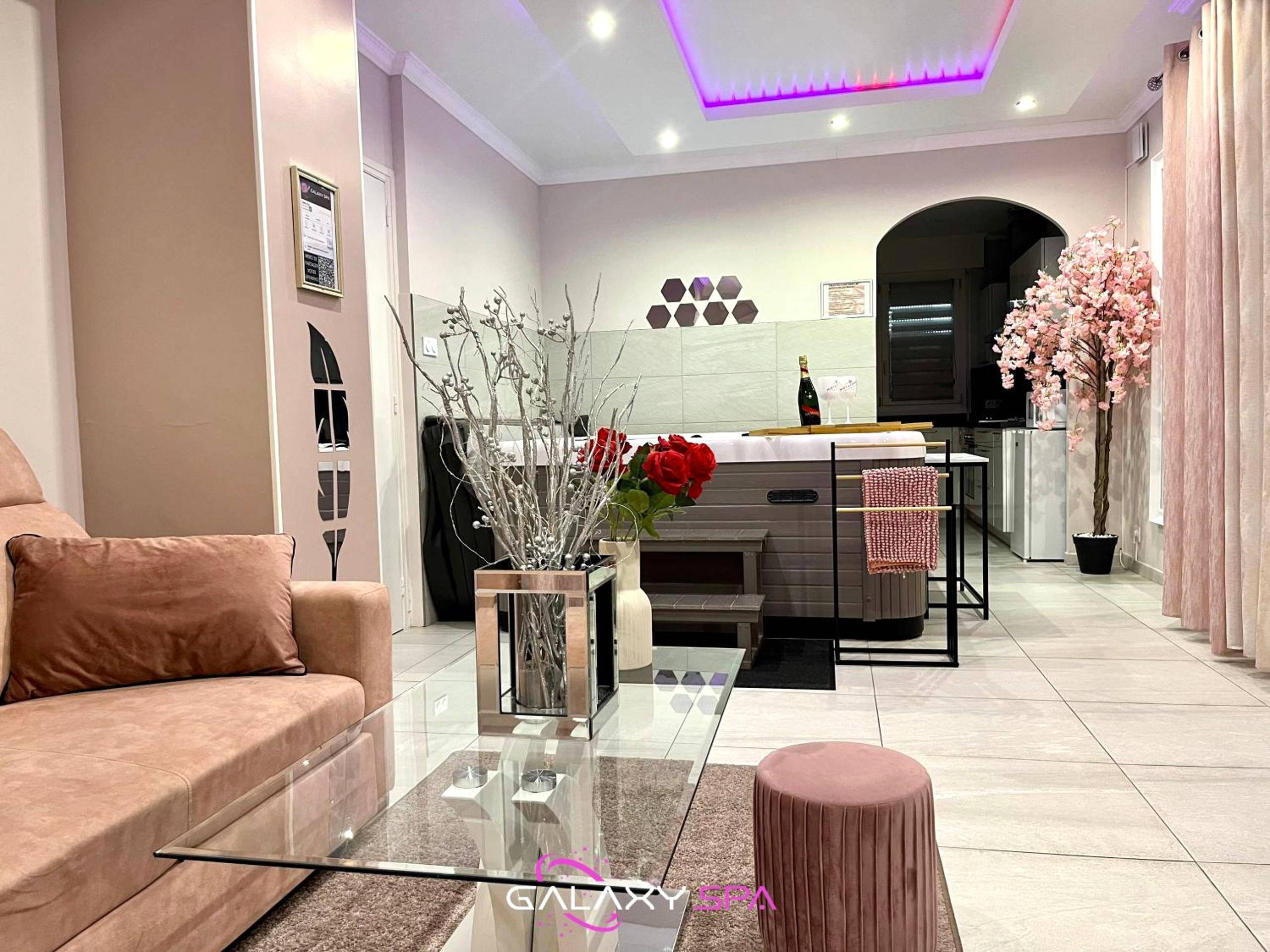 Salon avec canapé velours et table basse - GALAXY SPA - Suite Venus Jacuzzi et Sauna Privatif