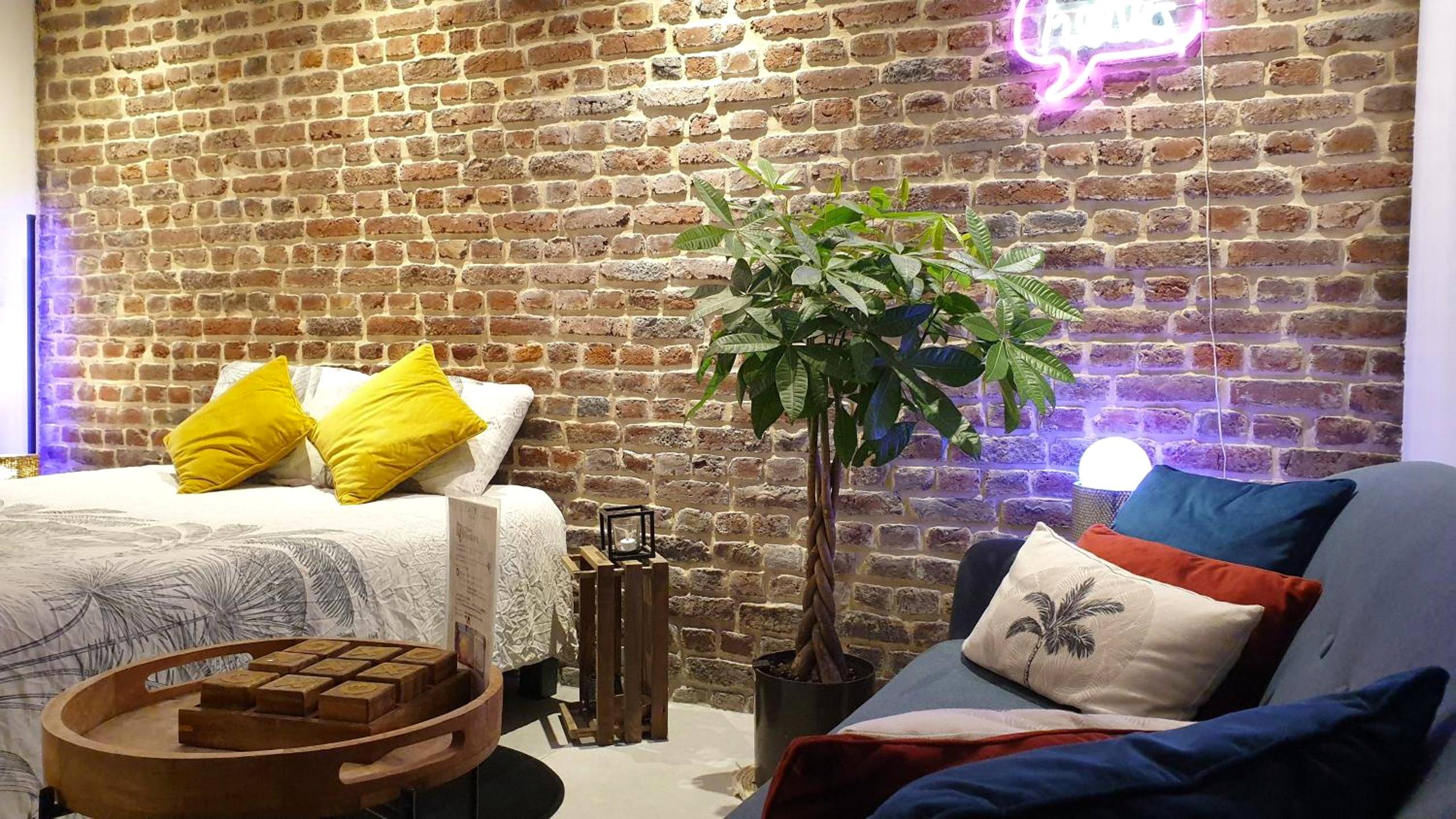 Lit double devant un mur en briques apparentes - GARY Suite - Studio Cosy, Spa et jardin privatif à 4 min de Cambrai