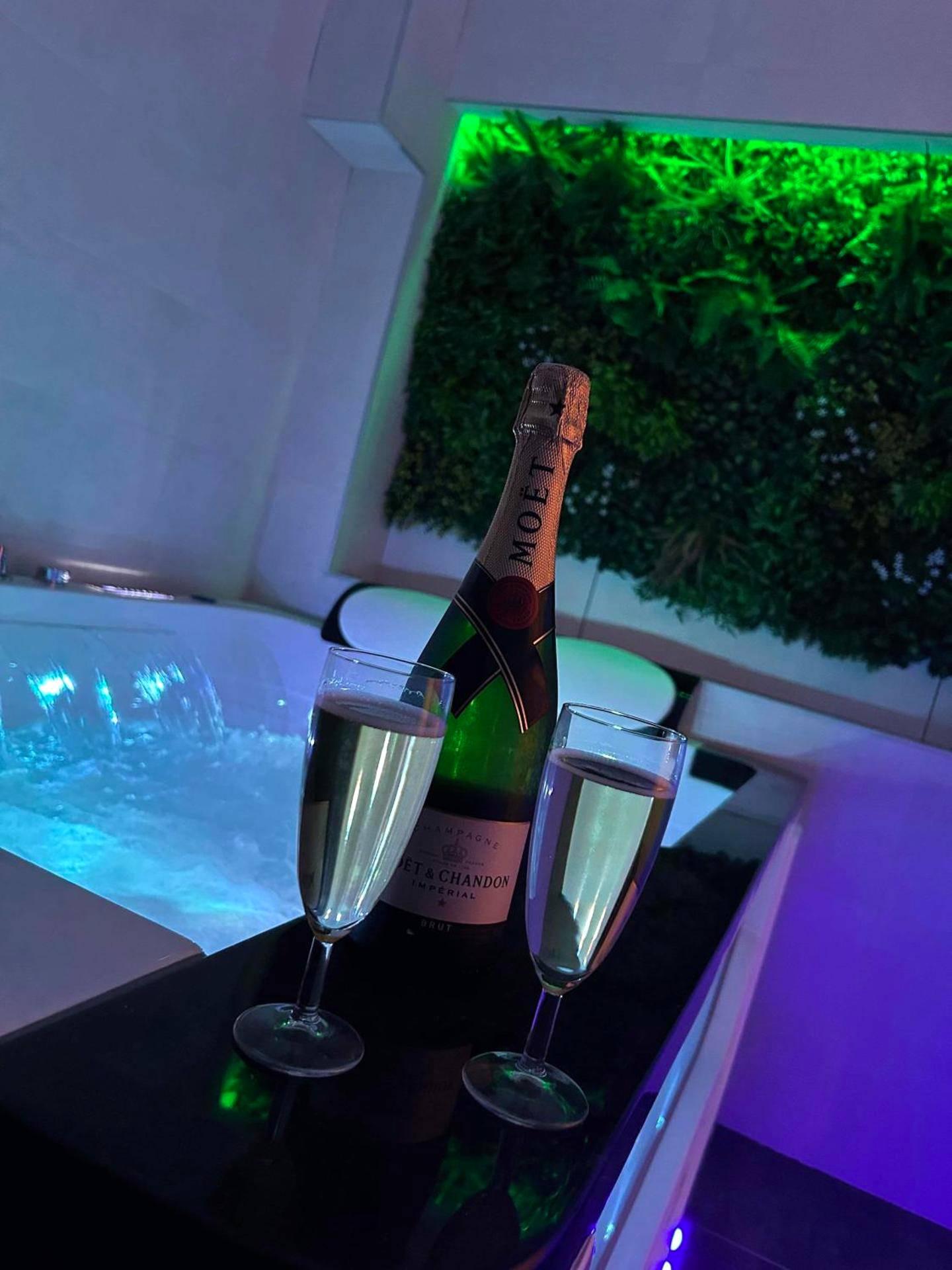Bouteille de champagne et coupes près du jacuzzi - Beau gîte avec jacuzzi