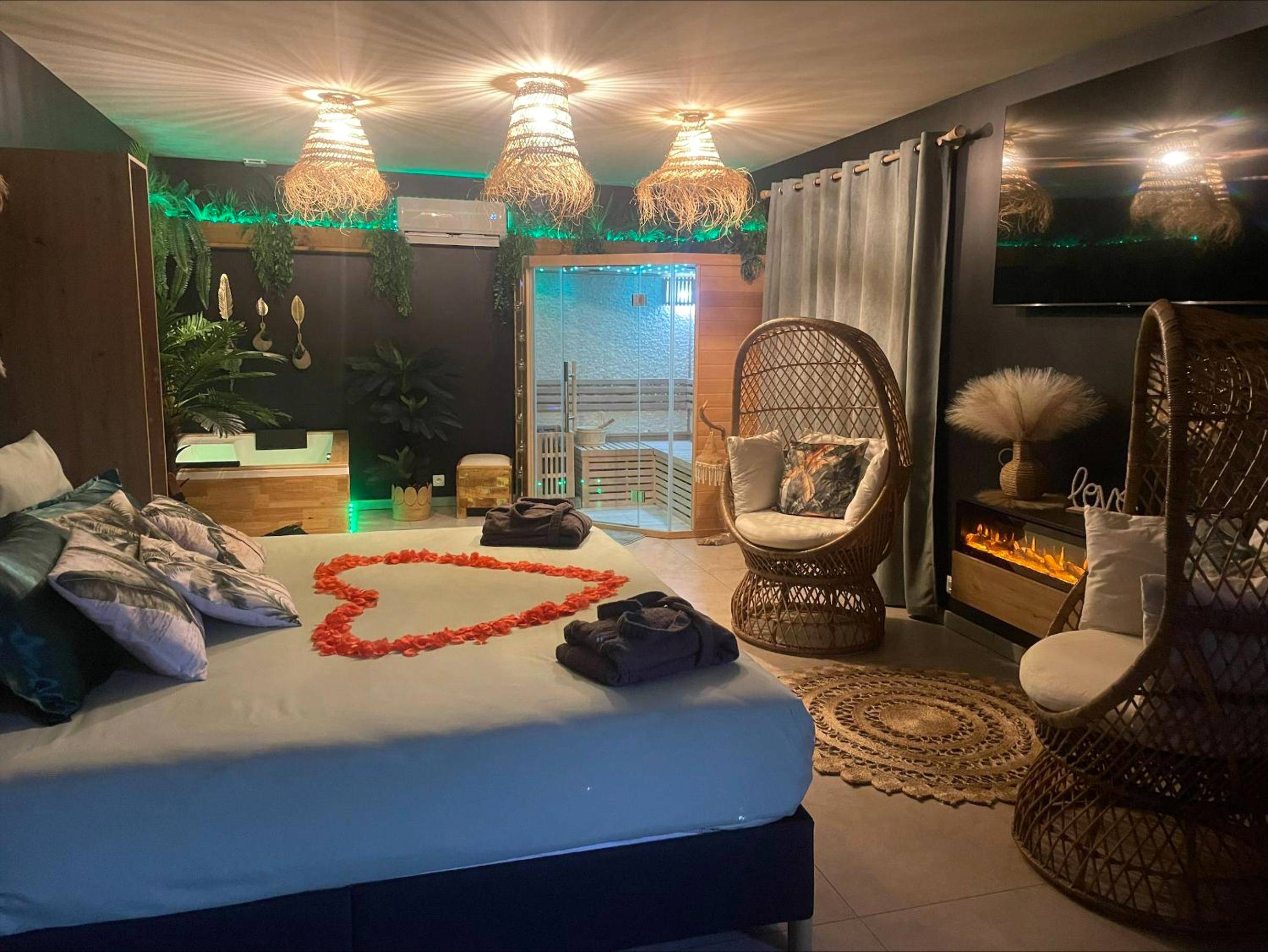 Lit avec cœur en pétales et fauteuils en osier - gîte romantique