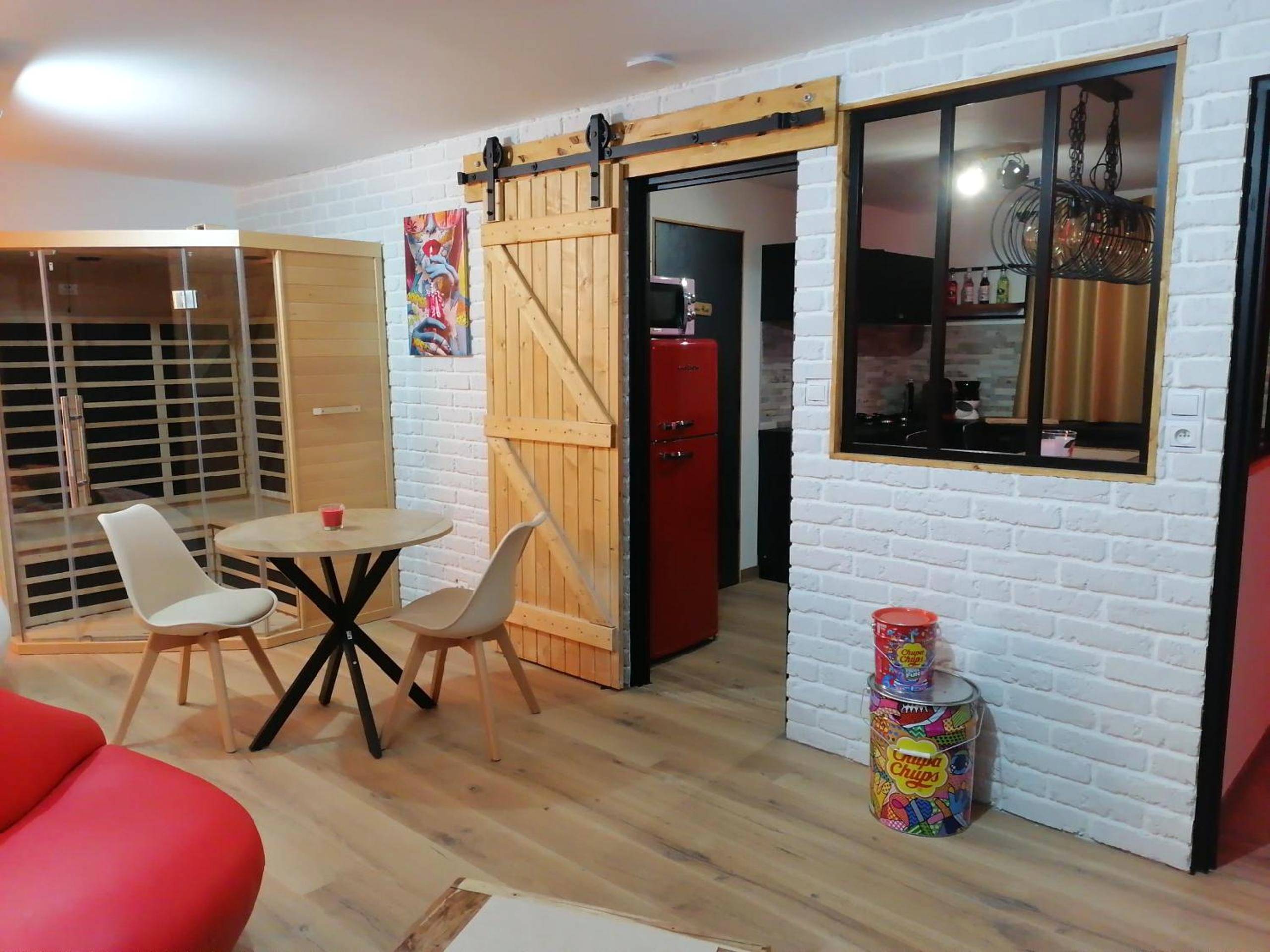 Espace repas avec porte de grange et sauna - Gîtes déco pop et chaleureuse avec jacuzzi, sauna, piece coquine