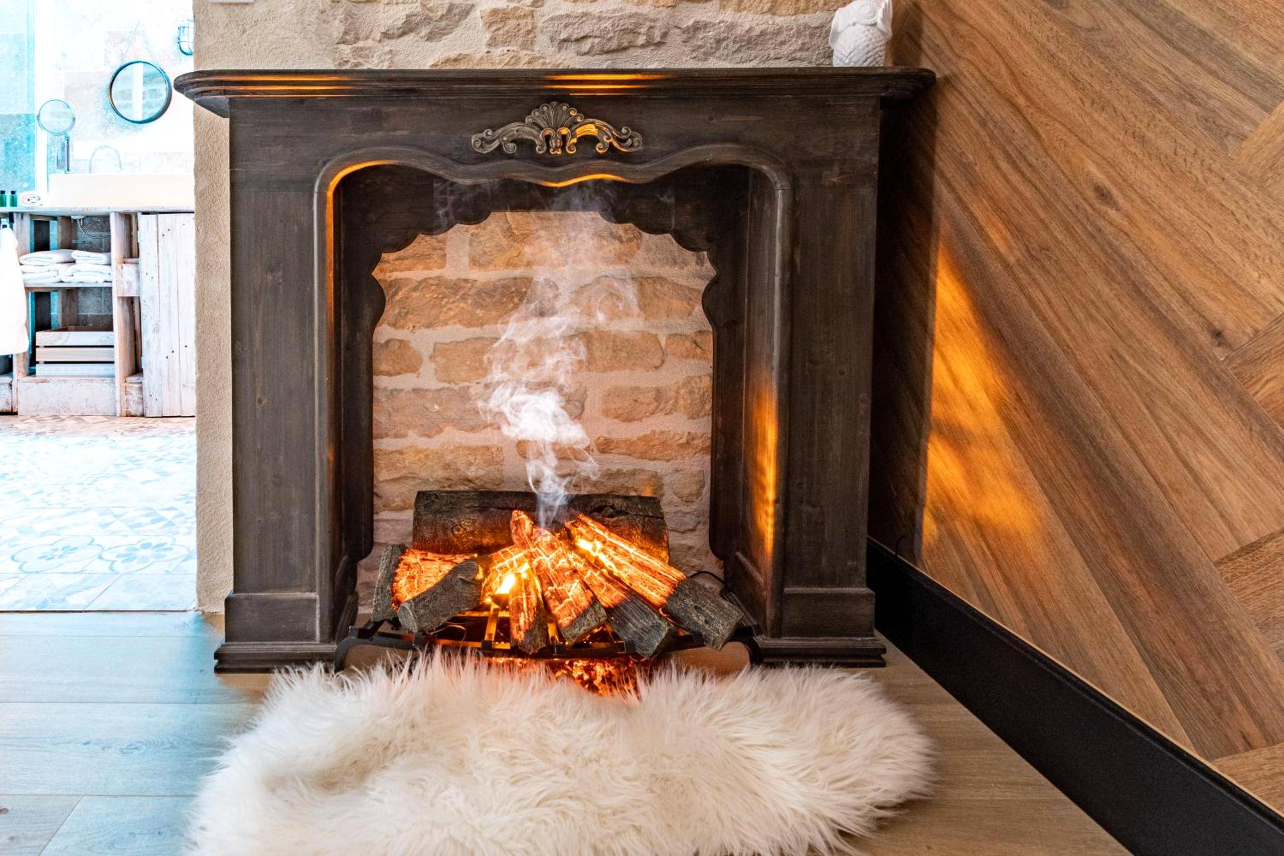 Cheminée décorative avec bûches et tapis fourrure - "glamappartspa" Chalet Cosy, Chill & Parking