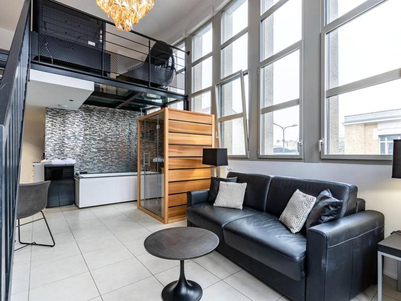 Salon avec canapé noir et sauna en bois - Love Room Reims - GlamappartSpa Prestige New - York expérience