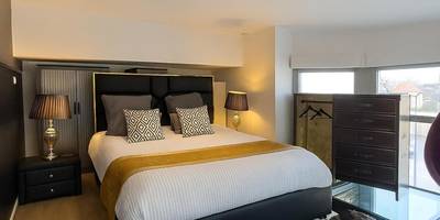 Chambre en mezzanine avec lit double et commode - GlamappartSpa Prestige New - York expérience