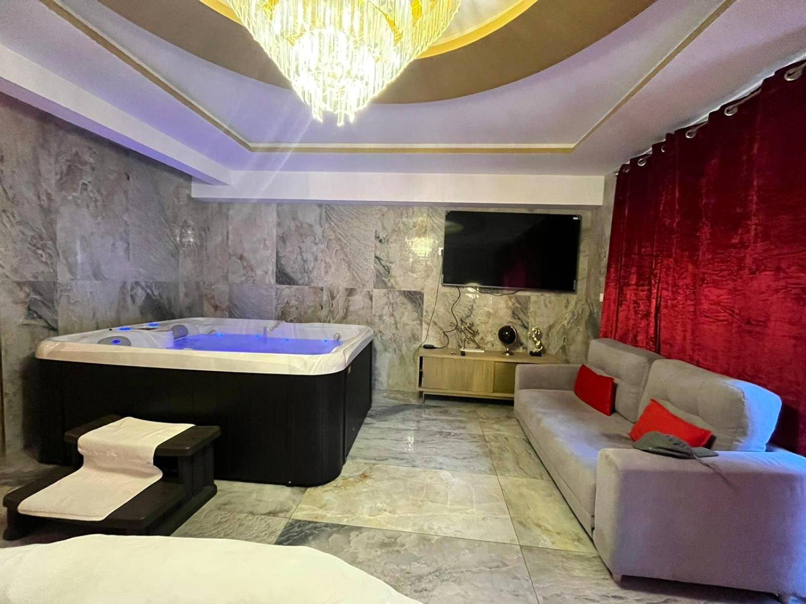 Salon avec canapé gris et jacuzzi rétroéclairé - Golden Love - Jacuzzi