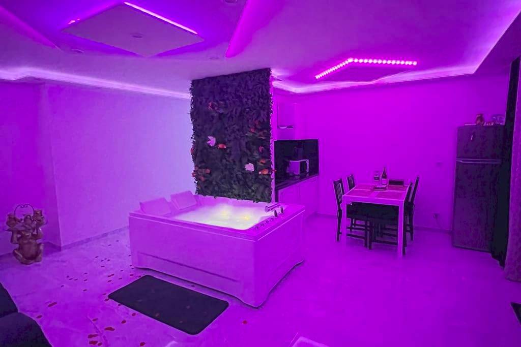 Jacuzzi privatif sous éclairage néon violet - Love Room Strasbourg - Golden seconds