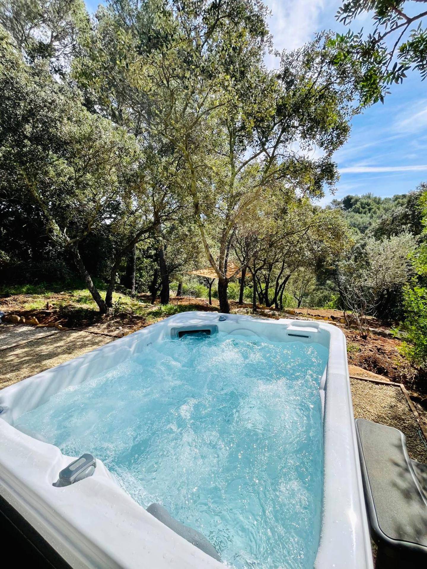 Jacuzzi extérieur bouillonnant sous les arbres - Love Room Le Beausset - La grange des amoureux piscine jacuzzi et massages