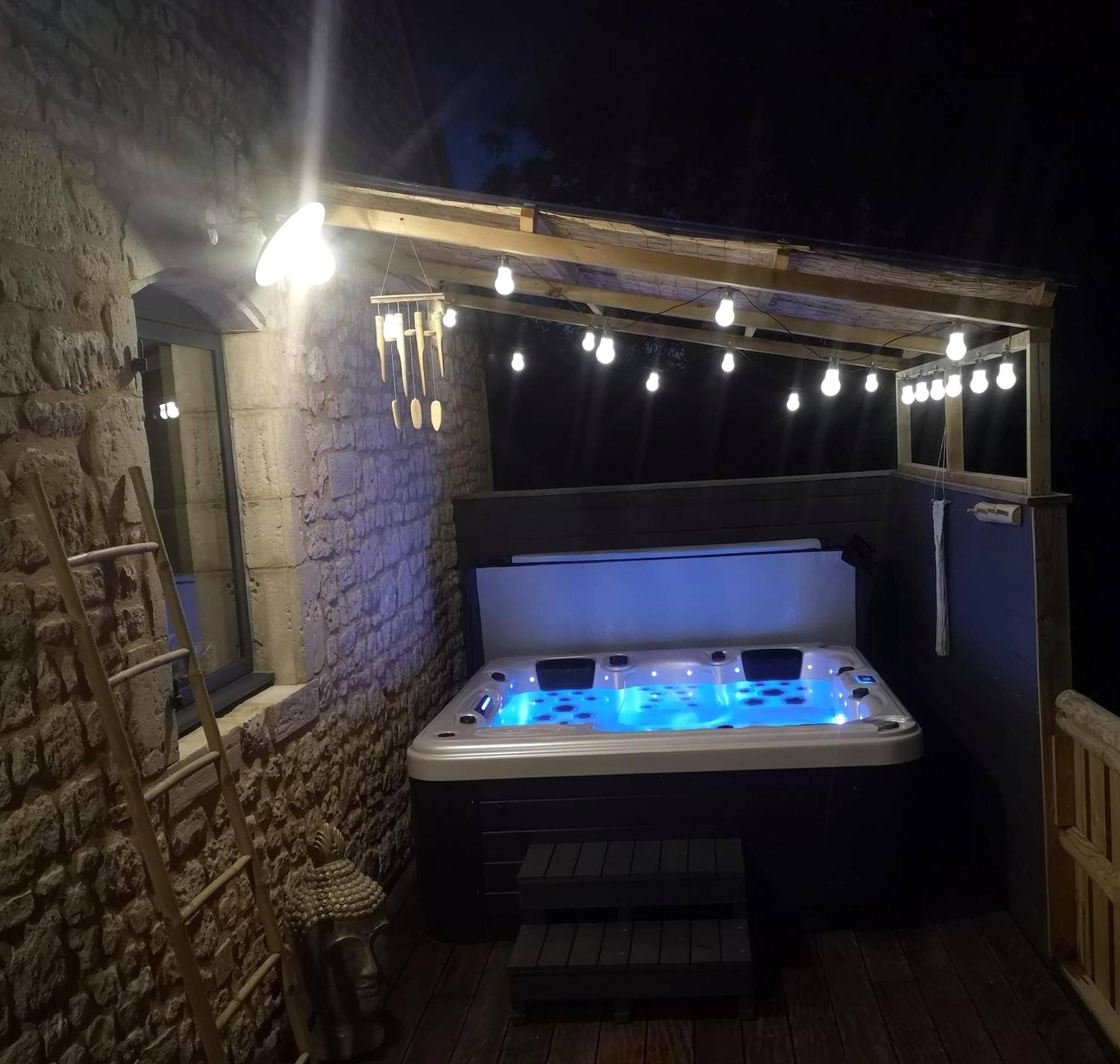 Jacuzzi extérieur sous abri avec guirlandes - Love Room Valognes - Gîte La Grange de La Trigalle avec spa professionnel...