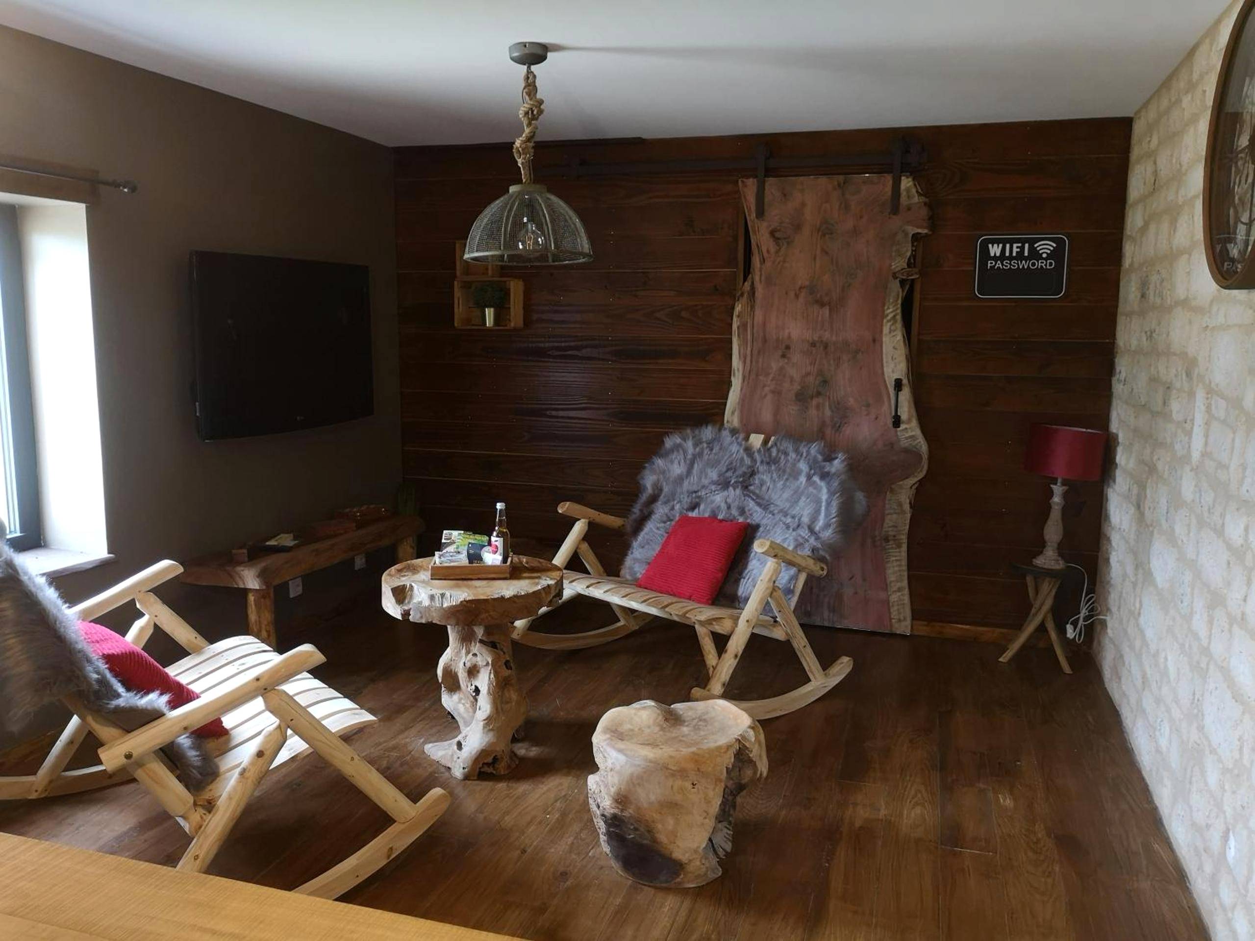Salon rustique avec fauteuils à bascule en bois - Gîte La Grange de La Trigalle avec spa professionnel privatif