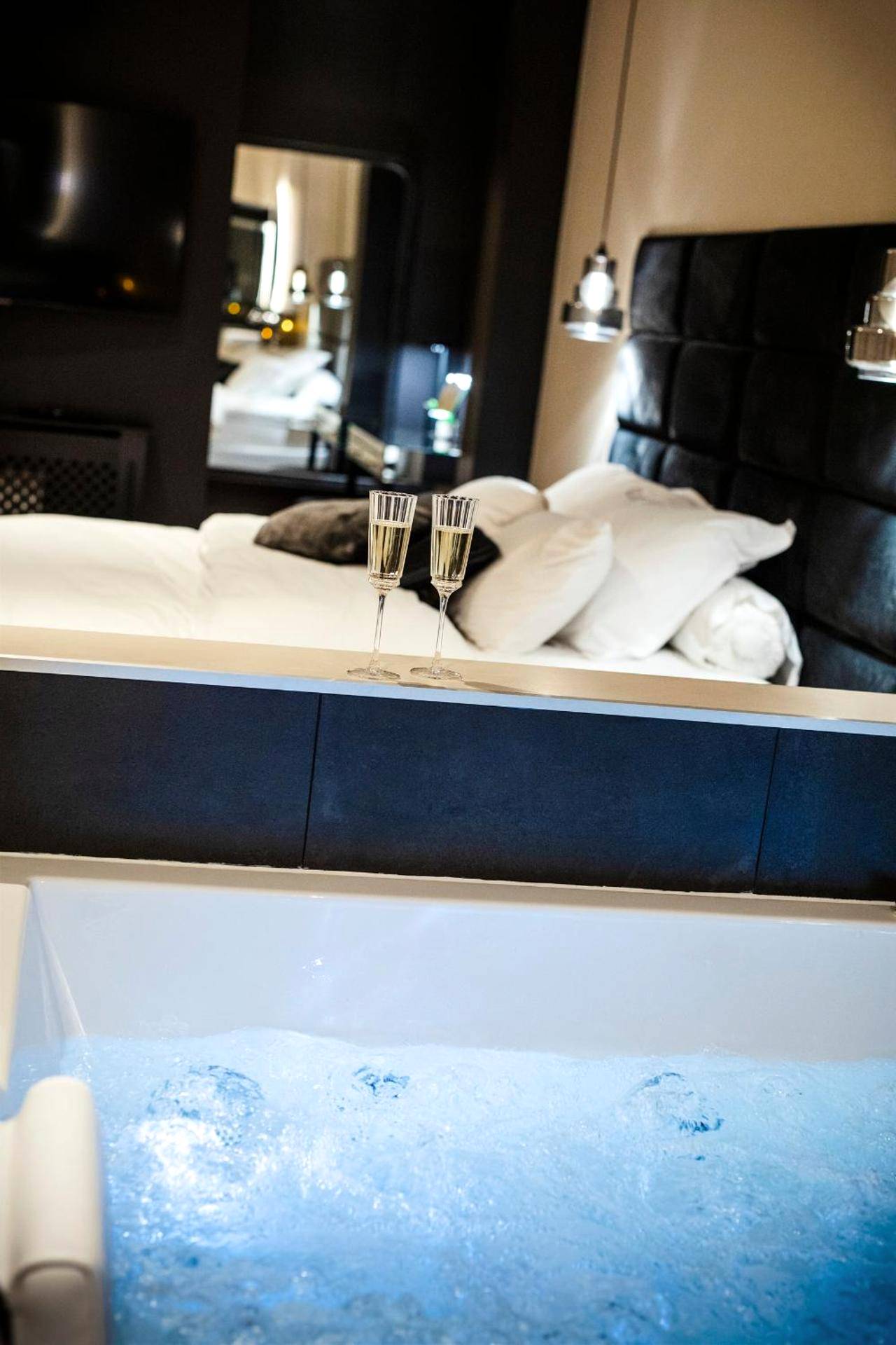 Baignoire balnéo et coupes de champagne - Love Room Nancy - Hédoné Suite de luxe et Spa privatif