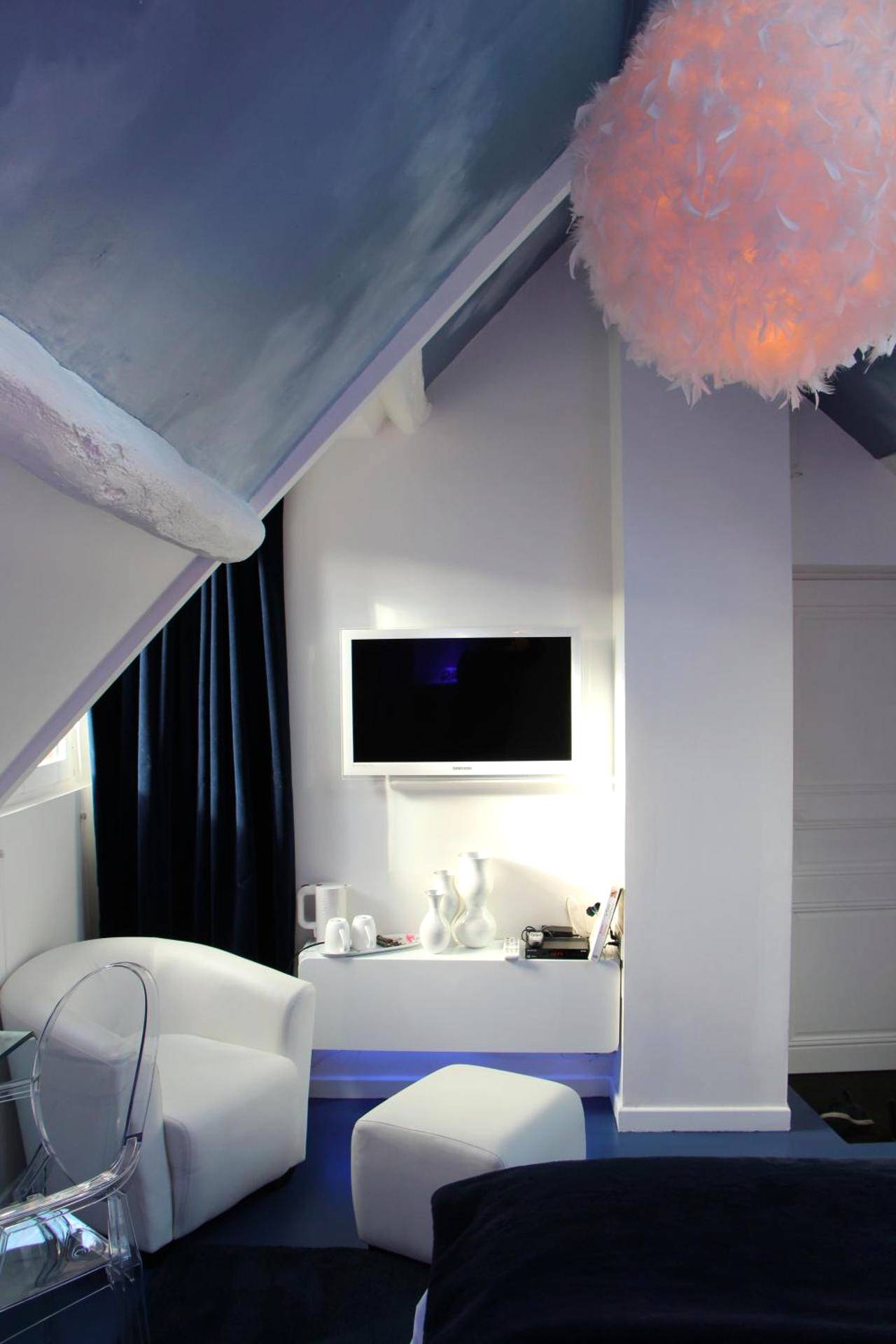 Coin salon avec fauteuil blanc et luminaire plume - L'Hibernie