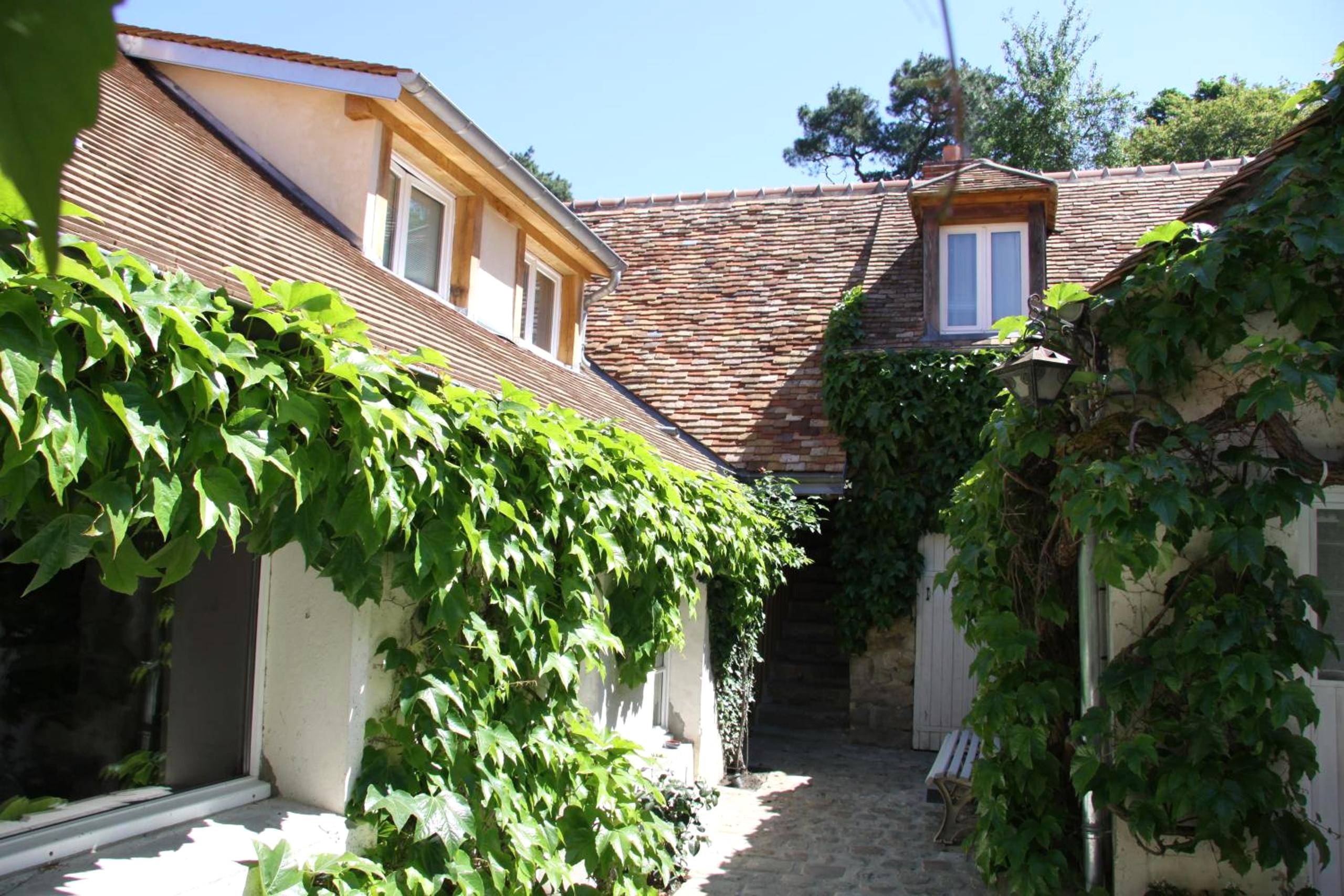 Façade en pierre avec lierre et toit de tuiles - L'Hibernie