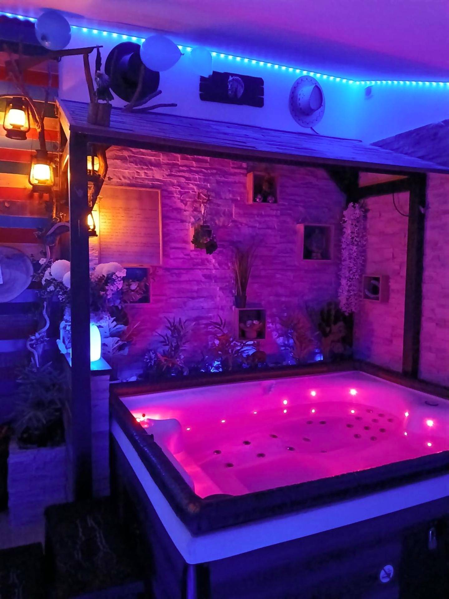 Jacuzzi privatif avec éclairage rose et bleu - Love Room Dole - L'histoire de l'ouest , jacuzzi appartement