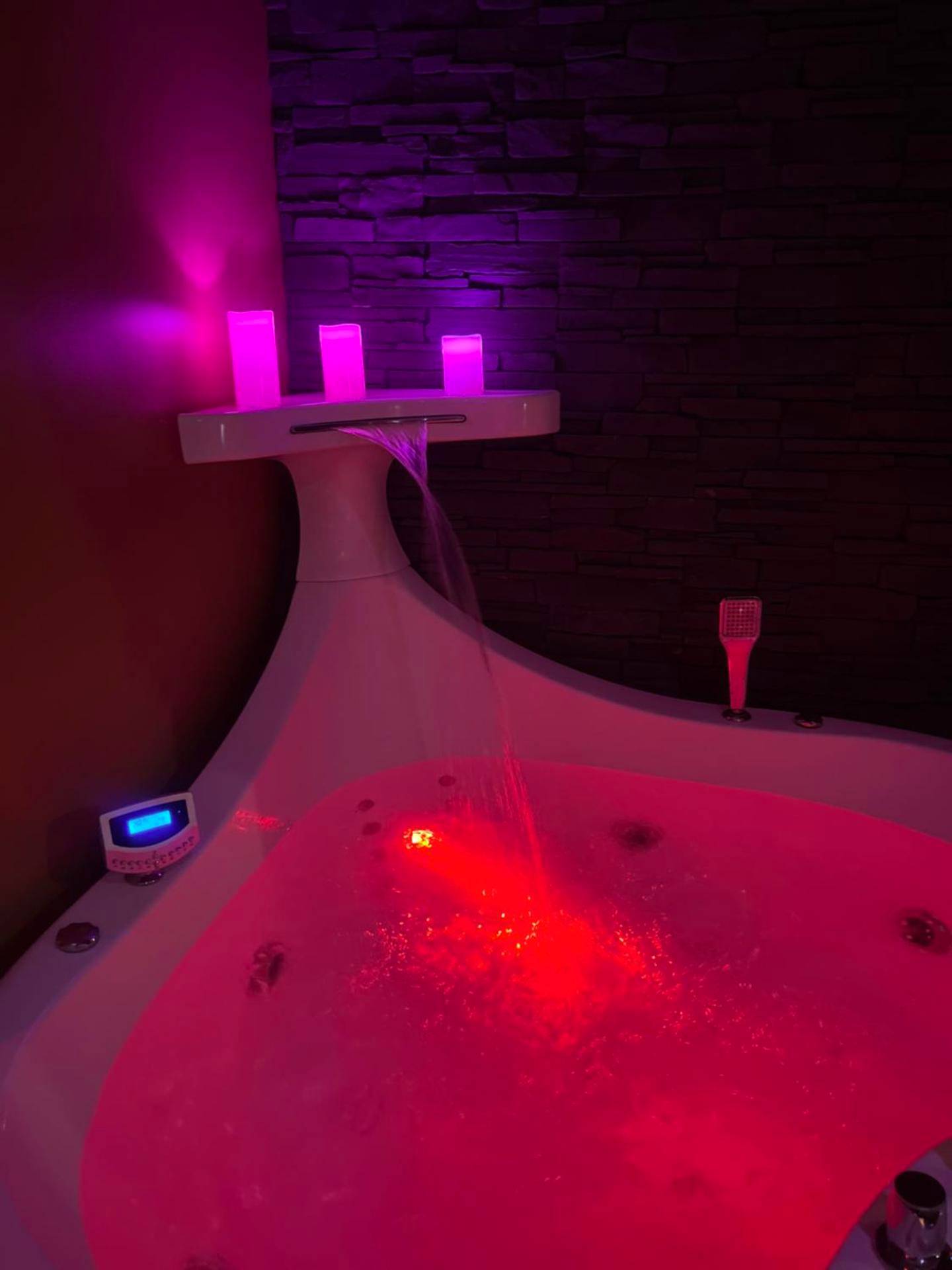 Jacuzzi privatif avec cascade et LED rouges - Love Room Besançon - HomeSparadise