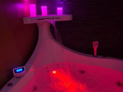 Jacuzzi privatif avec cascade et LED rouges - Love Room Besançon - HomeSparadise