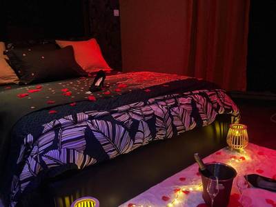 Lit décoré de pétales avec champagne au sol - HomeSparadise