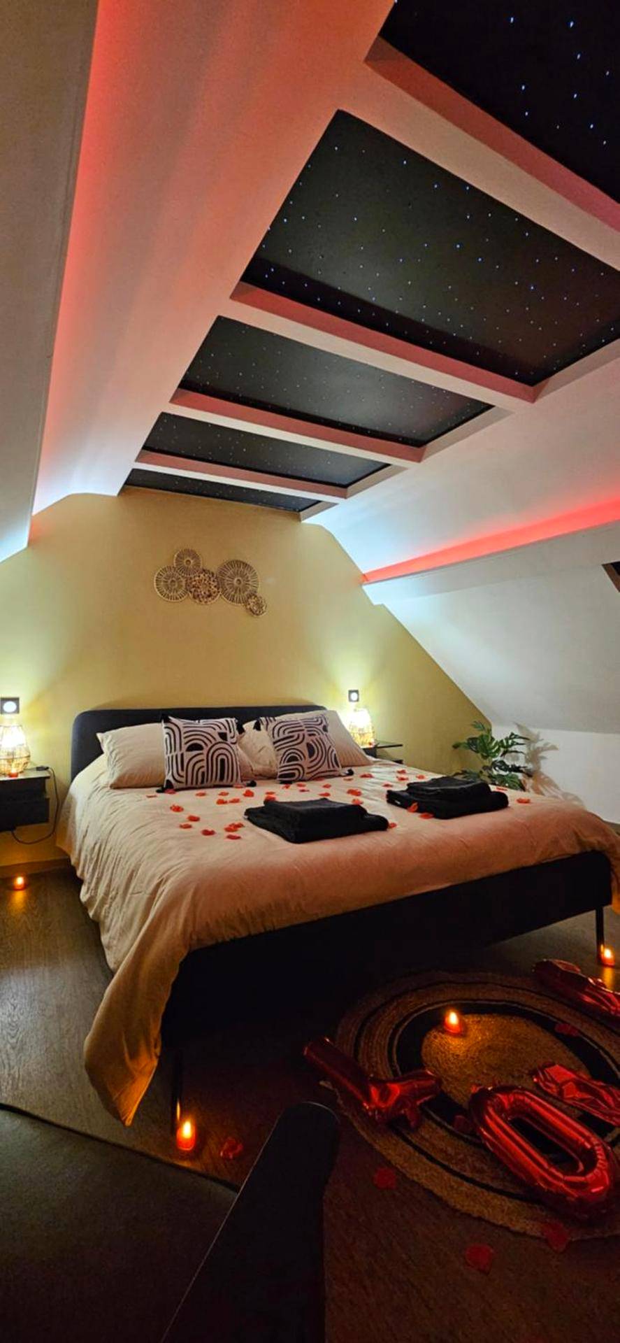 Lit avec pétales de rose et ciel étoilé - L'Hortillon