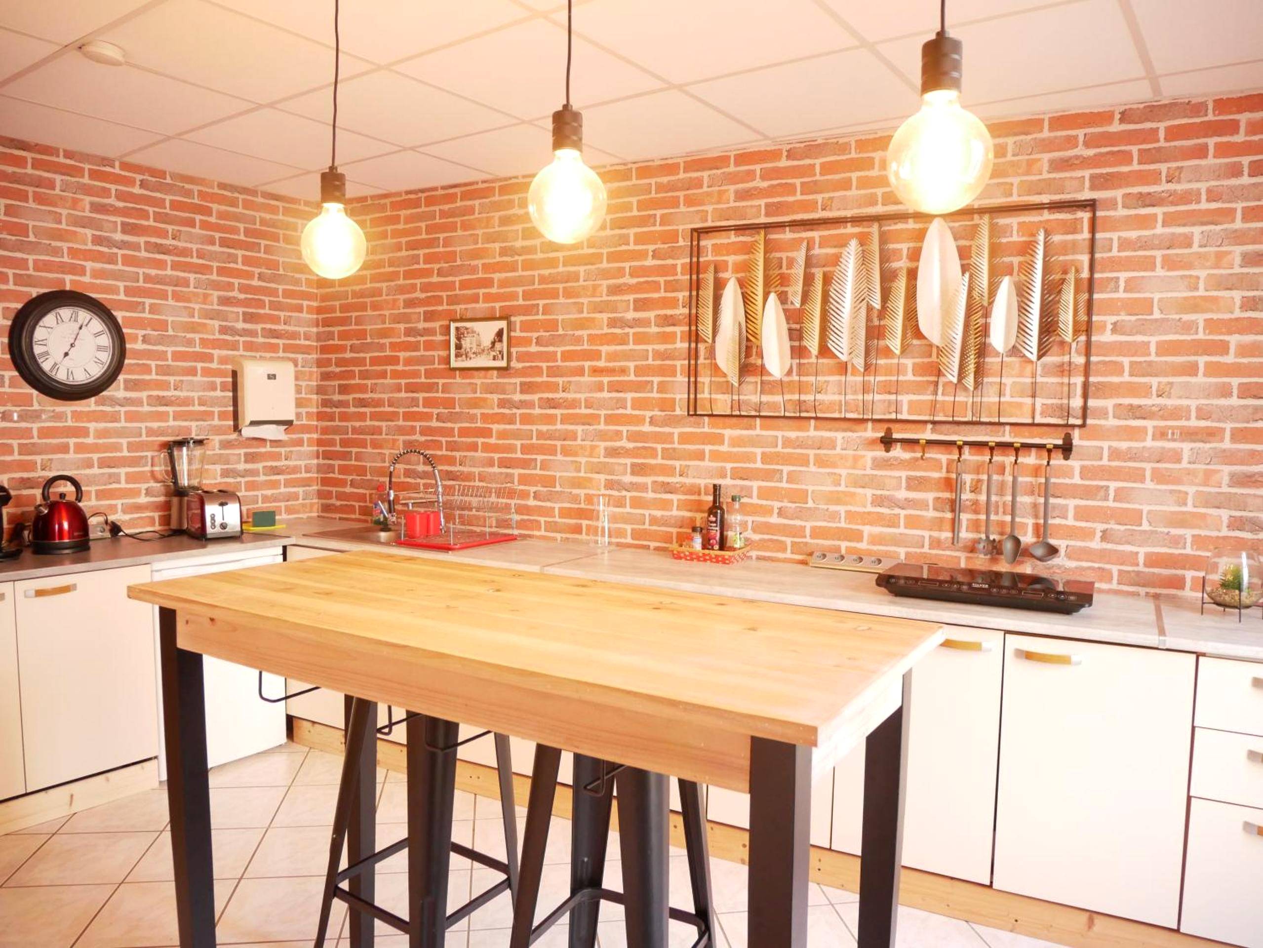 Cuisine équipée avec îlot central et mur briques - HOTEL DU BERRY - Loveroom avec Sauna, Hammam, Jacuzzi privatifs