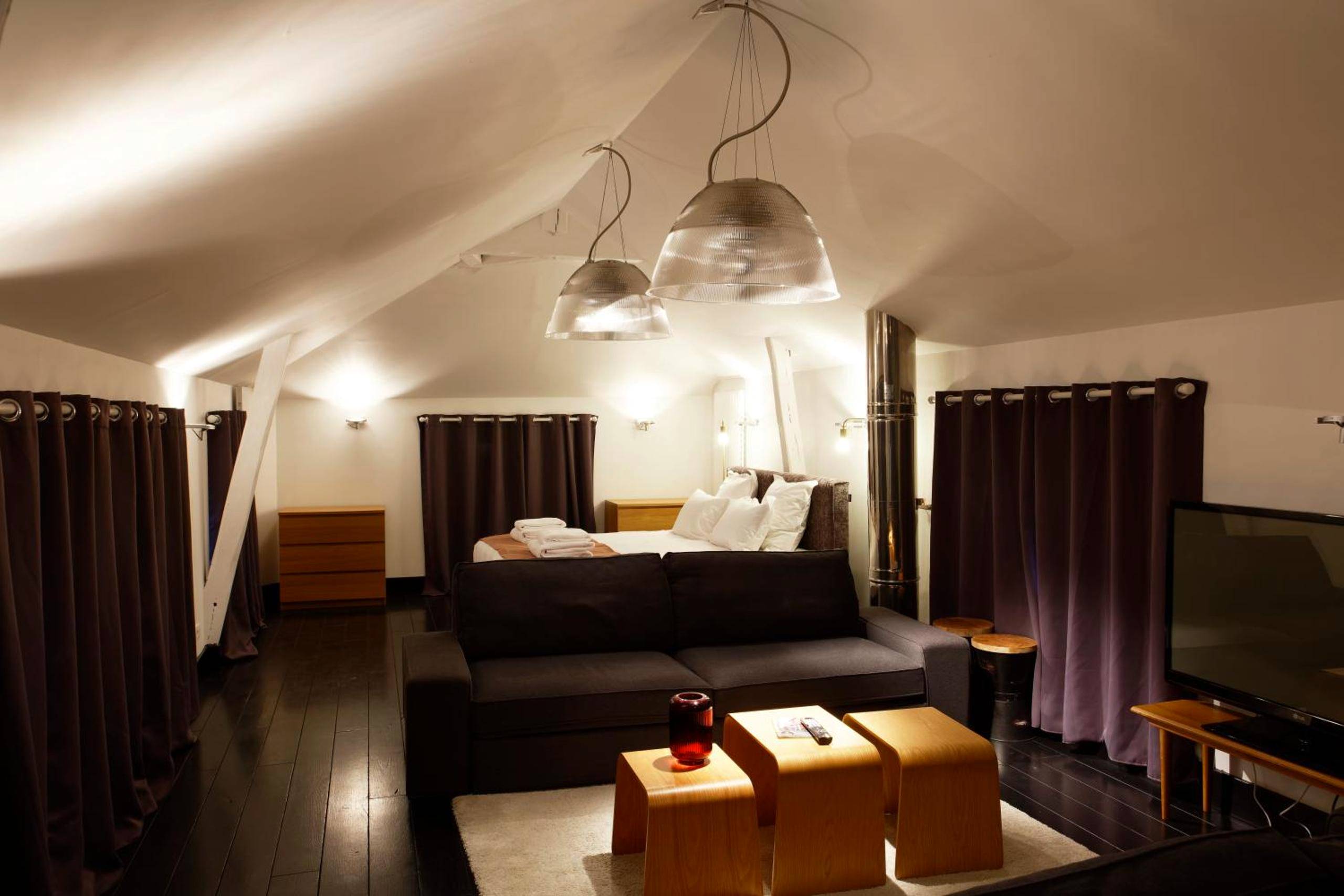 Salon mansardé avec canapé et lit en fond - L'HOTEL PARTICULIER - LE MANS