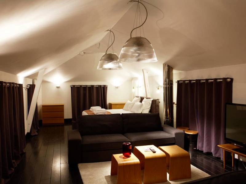 Salon mansardé avec canapé et lit en fond - L'HOTEL PARTICULIER - LE MANS