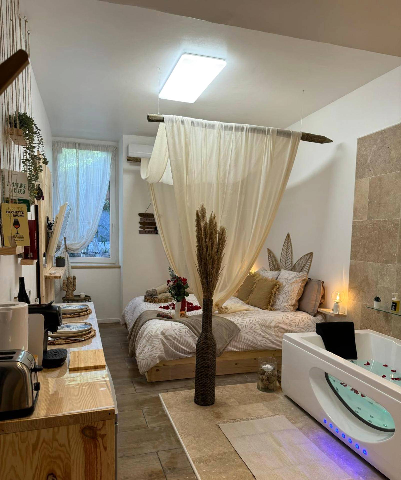 Vue d'ensemble de la suite avec jacuzzi et lit - l'Idylle - Coeur de Bastide - balnéo - Clim