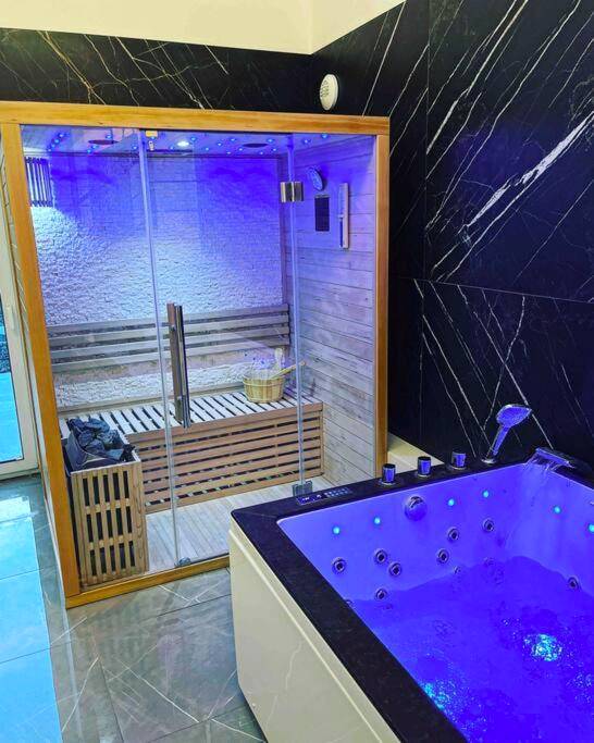Jacuzzi et sauna dans un décor de marbre noir - L’insolite airbnb