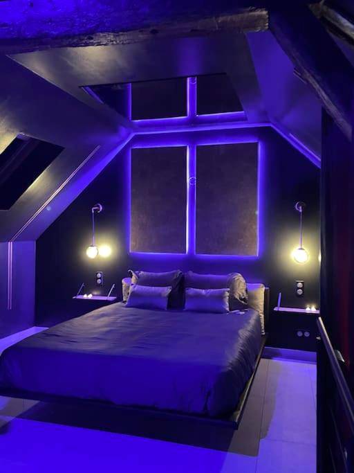 Chambre sous comble avec néons violets - Insolite Escapade avec Spa privatif