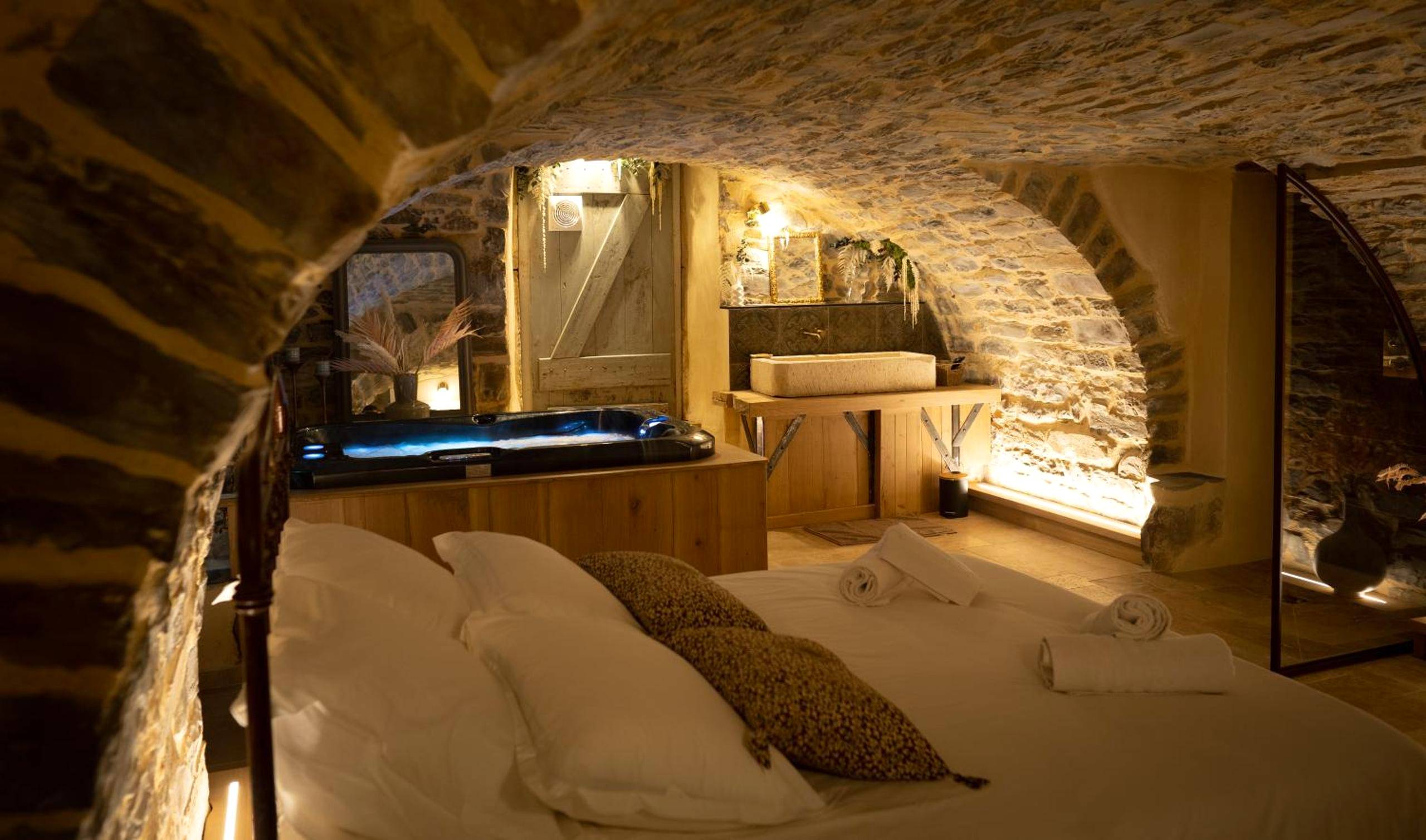 Lit double sous voûte en pierre et jacuzzi - Hébergement insolite avec jacuzzi privatif Millau