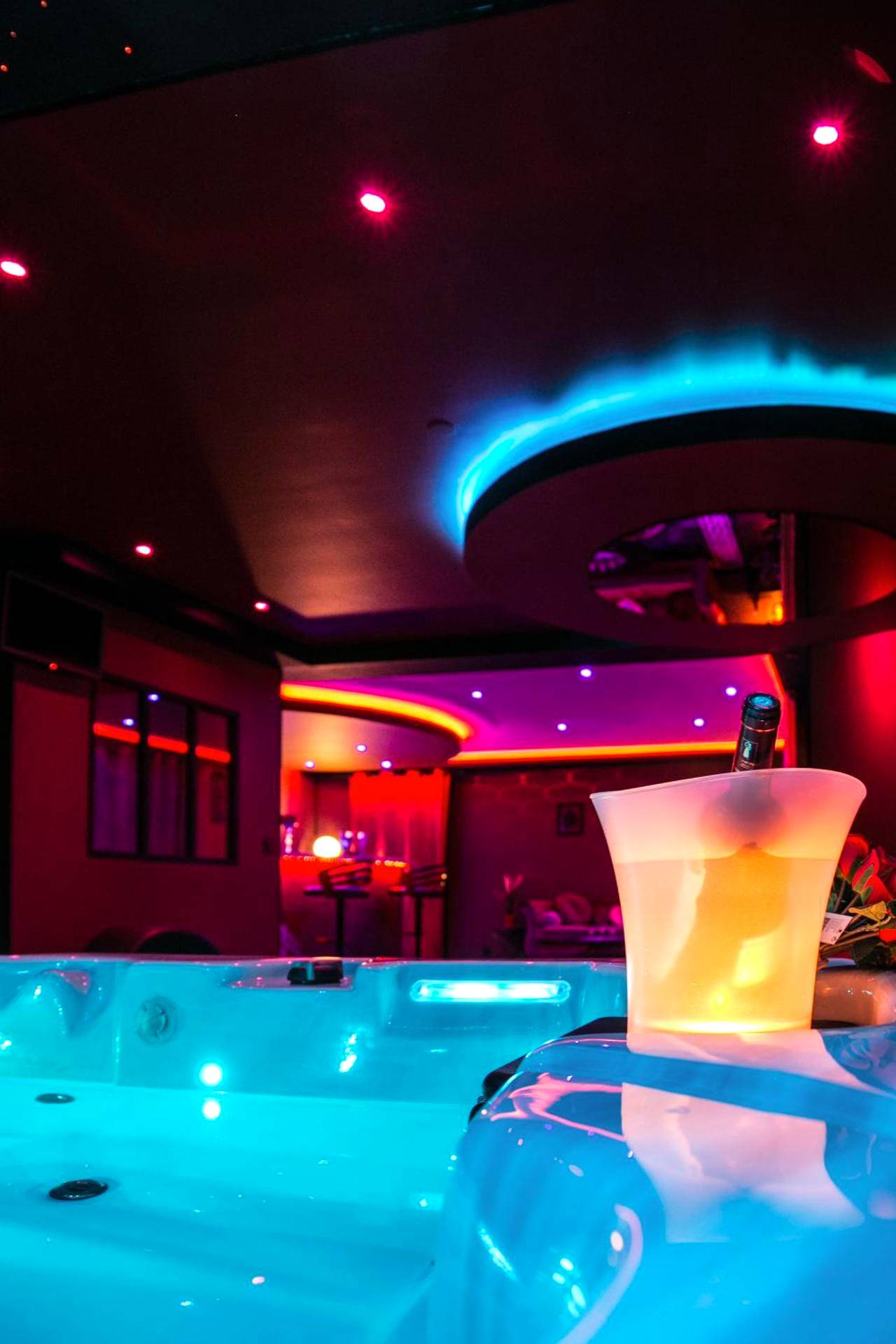 Bain à remous éclairé en bleu et seau à glace - L'Insolite Spa Privatif ''Suite Luxueuse - Jacuzzi"