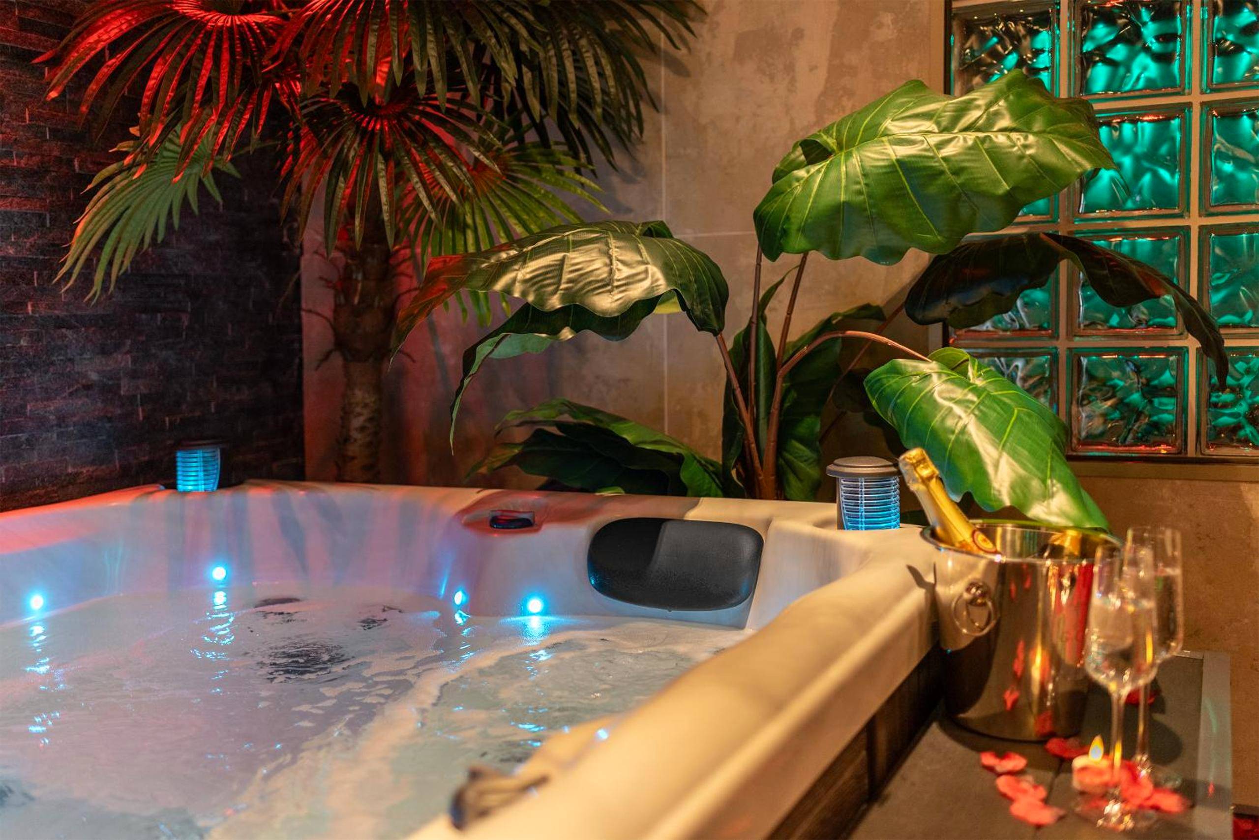 Détail jacuzzi avec champagne et pétales - L’Insolite, Spa Privatif (Appartement Jacuzzi)