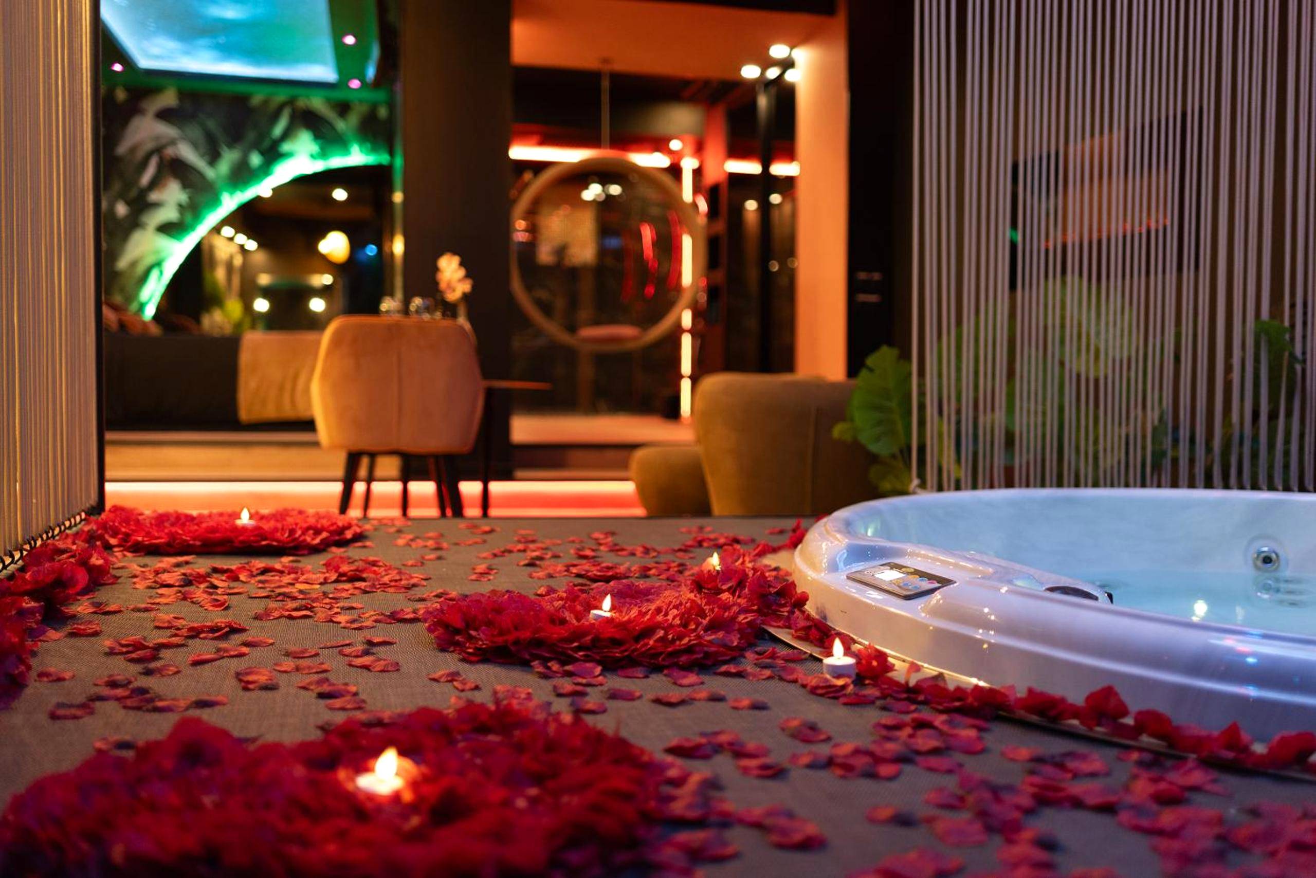 Pétales de roses et bougies près du jacuzzi - Suite intimiste Sainte - Insolite Spa Privatif Suite étoilée
