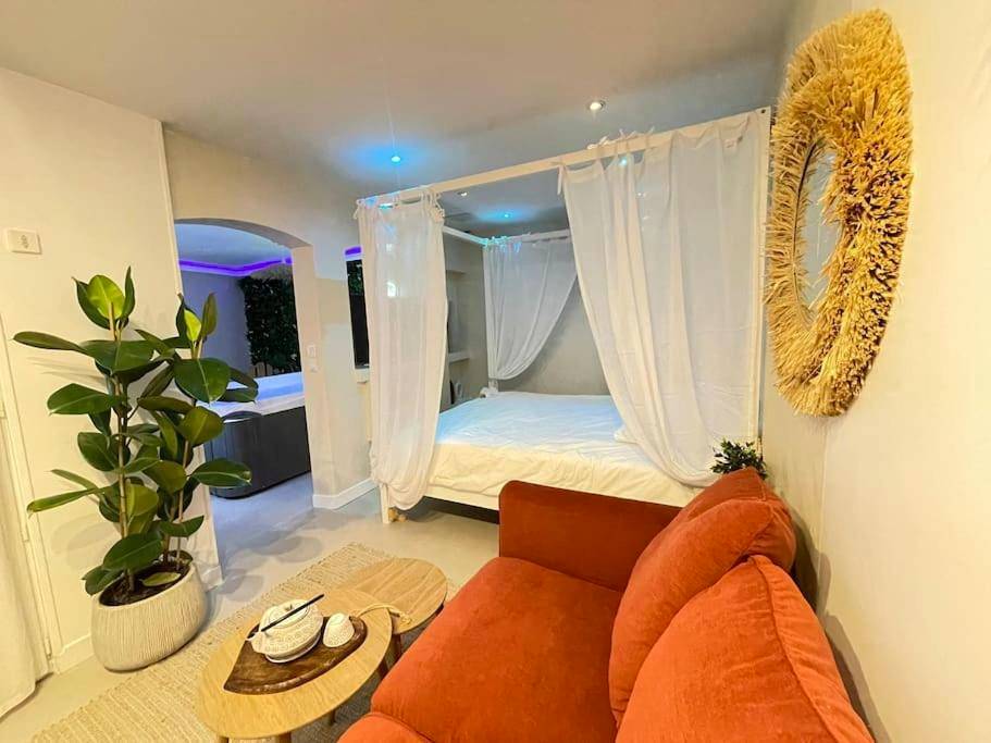 Salon cosy avec canapé rouge et lit à baldaquin - L'instant Bornéo Superbe appartement avec jacuzzi