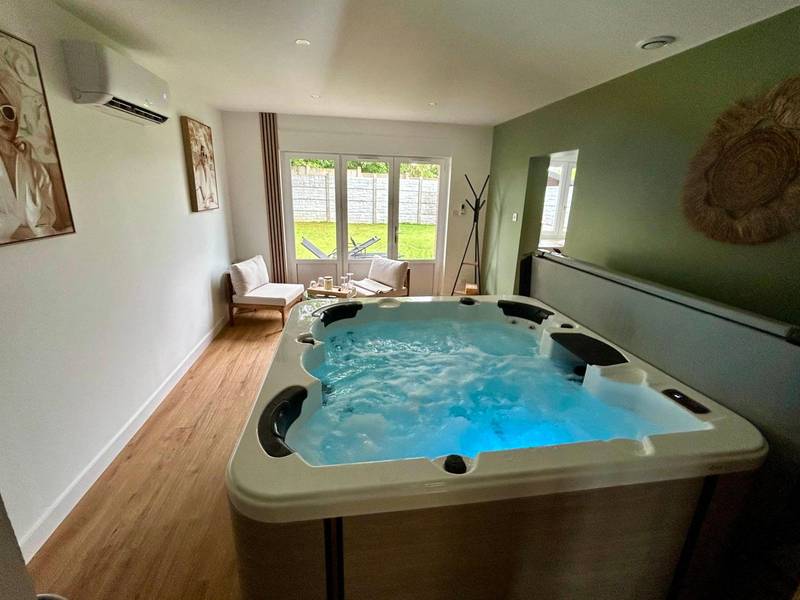 Jacuzzi privatif avec éclairage bleu - Love Room Maulde - L'instant SPA