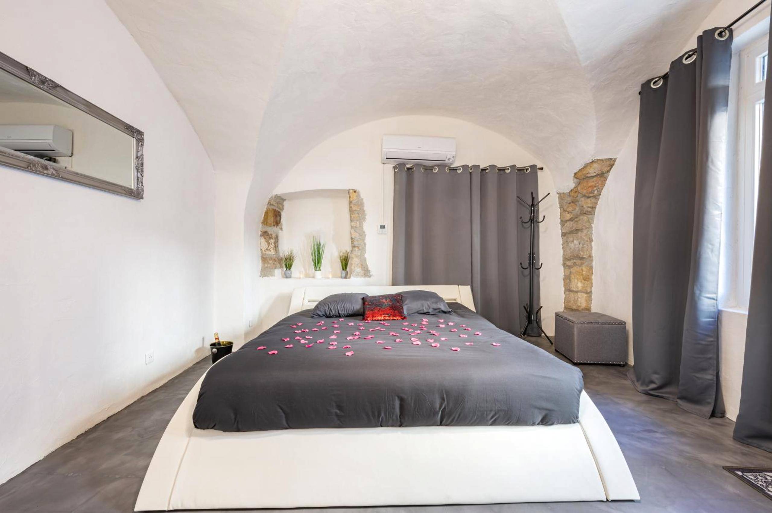 Lit double avec pétales de rose et voûtes - L'instant Suspendu