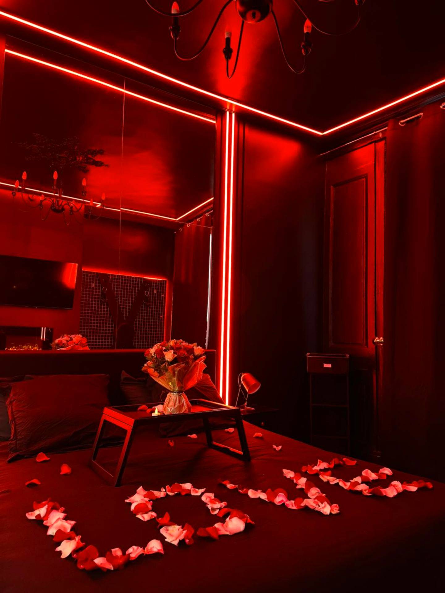 Lit avec pétales de rose et ambiance rouge - Love Room Rouen - Love Room, L'interdit