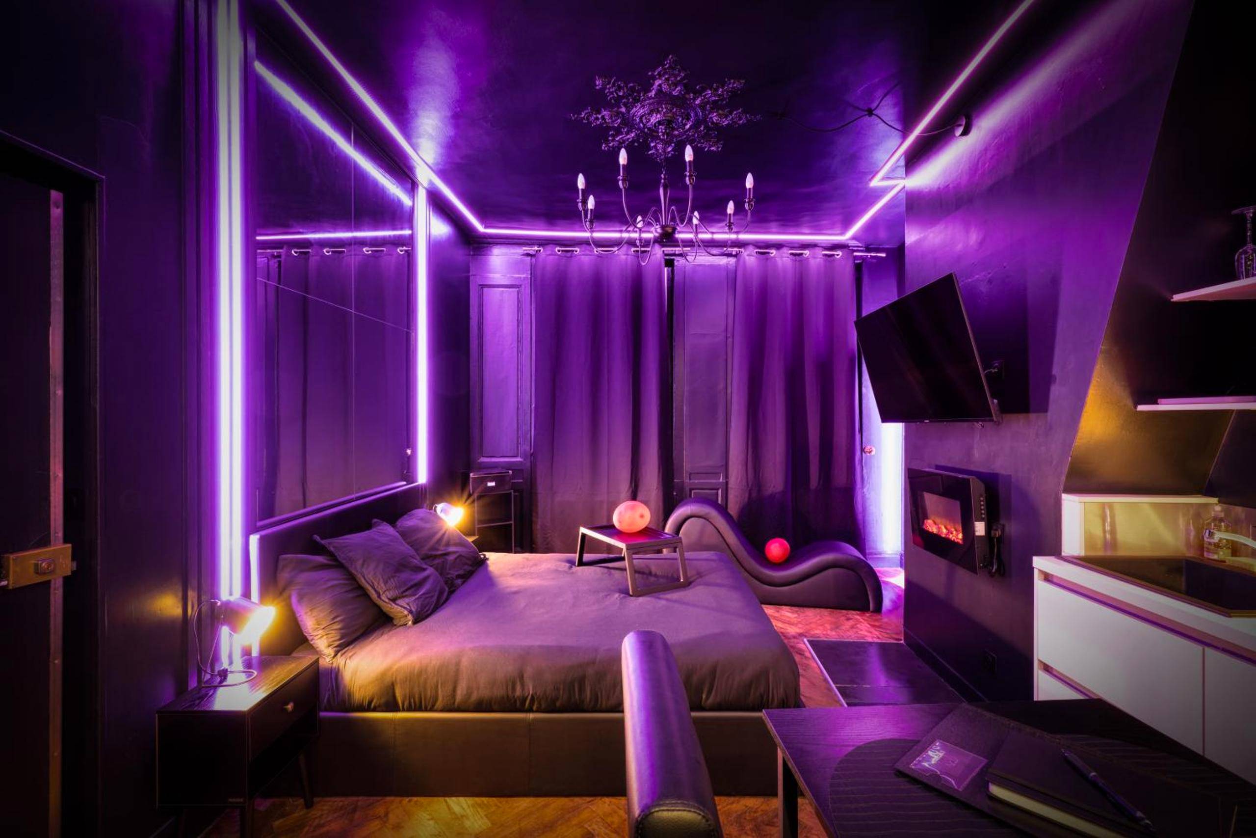 Chambre avec éclairage néon violet et sofa tantra - Love Room, L'interdit
