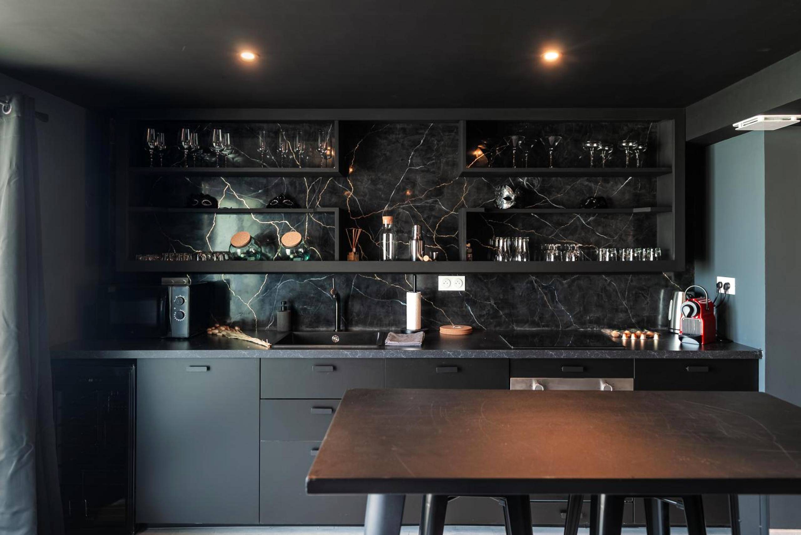 Cuisine moderne noire avec crédence marbrée - L'Interdit, Confort et Sensualité