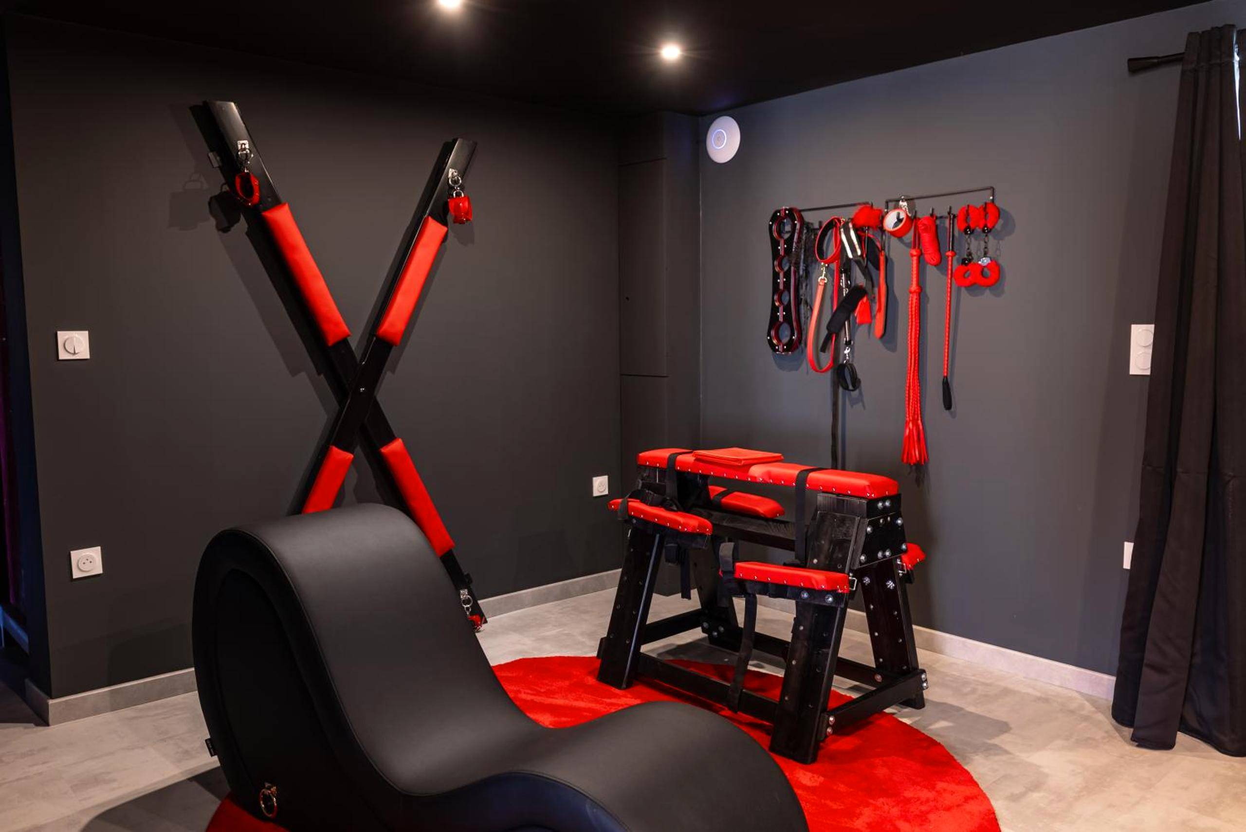 Espace BDSM avec croix de Saint - André et sofa - L'Interdit, Confort et Sensualité