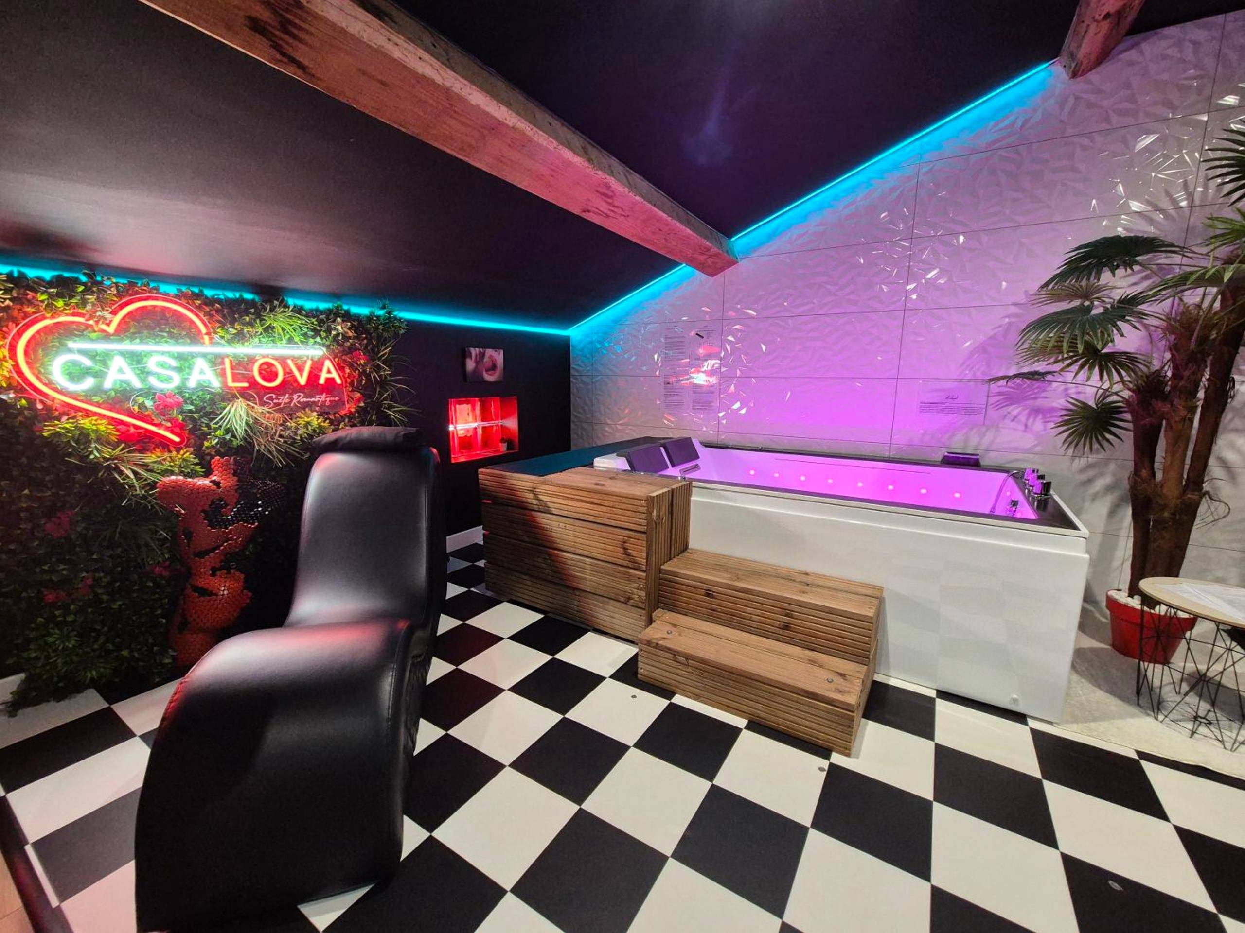 Baignoire balnéo lumineuse et fauteuil tantra - L'Interdit Suite Luxe Romantique Spa Balneo Sauna Hammam