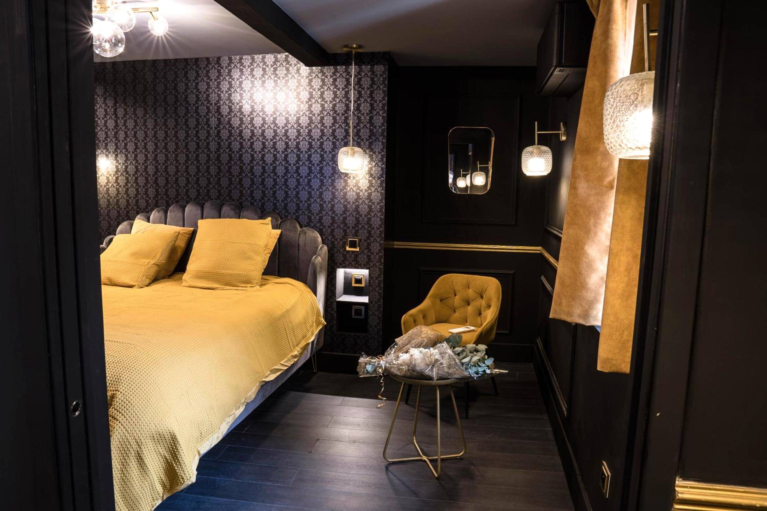 Chambre avec fauteuil et bouquet de fleurs - Superbe Appartement avec Jacuzzi...