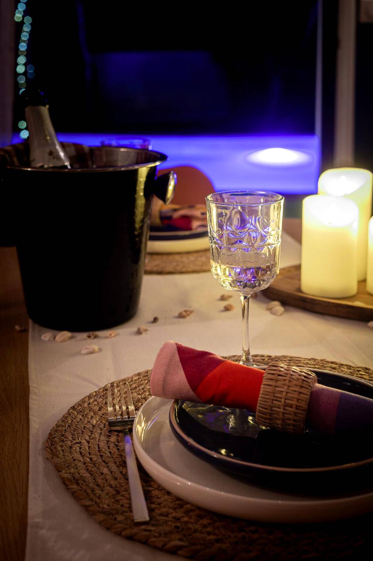 Table dressée avec bougies et seau à champagne - Love Room Biscarrosse - Logement romantique avec jacuzzi privatif