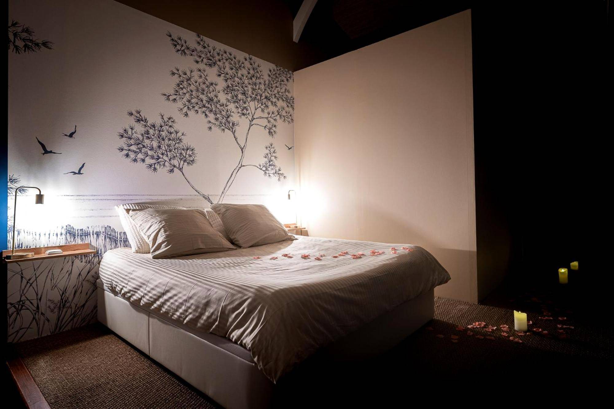 Lit double avec pétales de rose et fresque murale - Logement romantique avec jacuzzi privatif