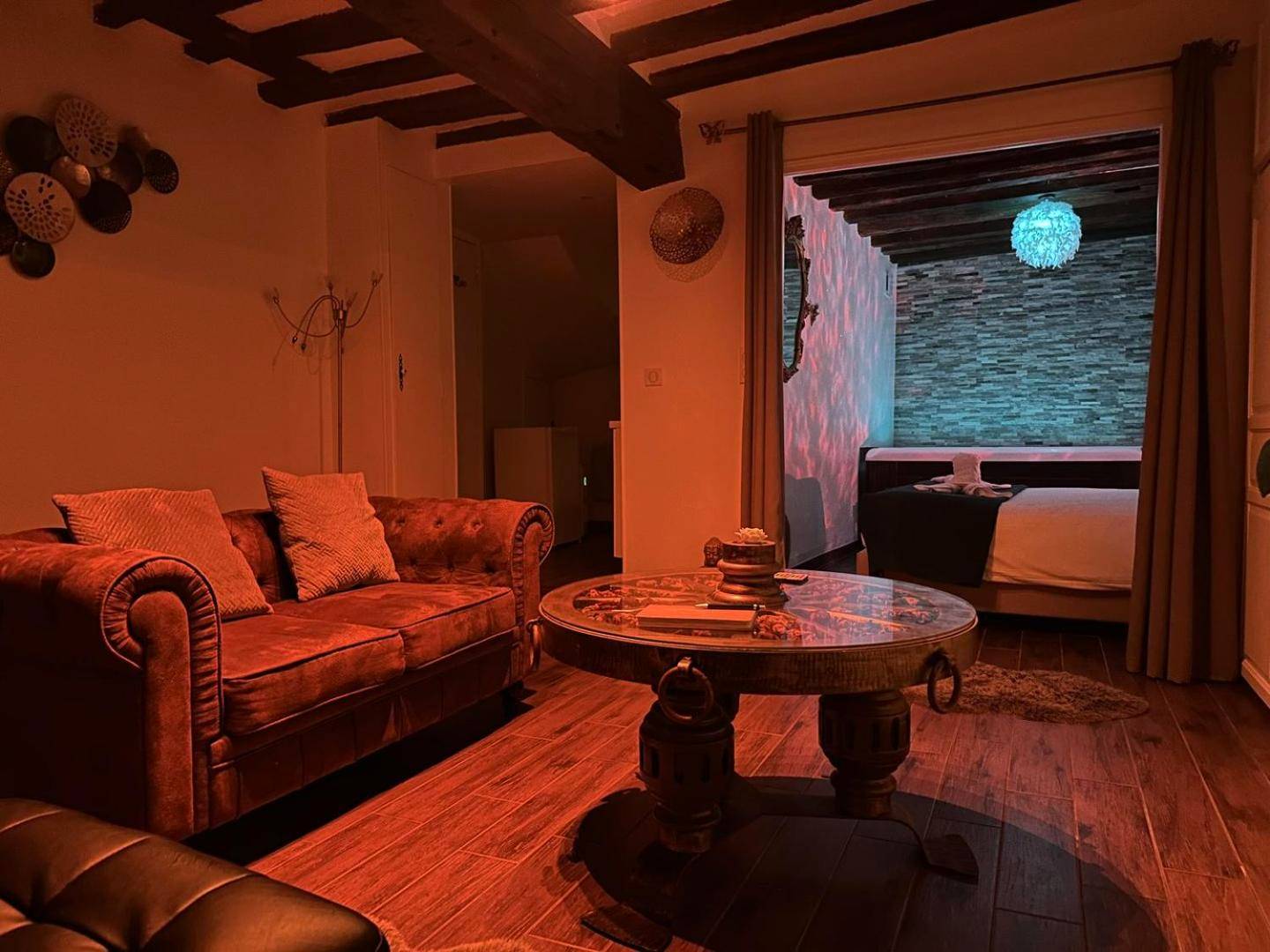 Salon avec ambiance lumineuse rouge et jacuzzi - Appartement et Jacuzzi privatif, cœur de Chartres.
