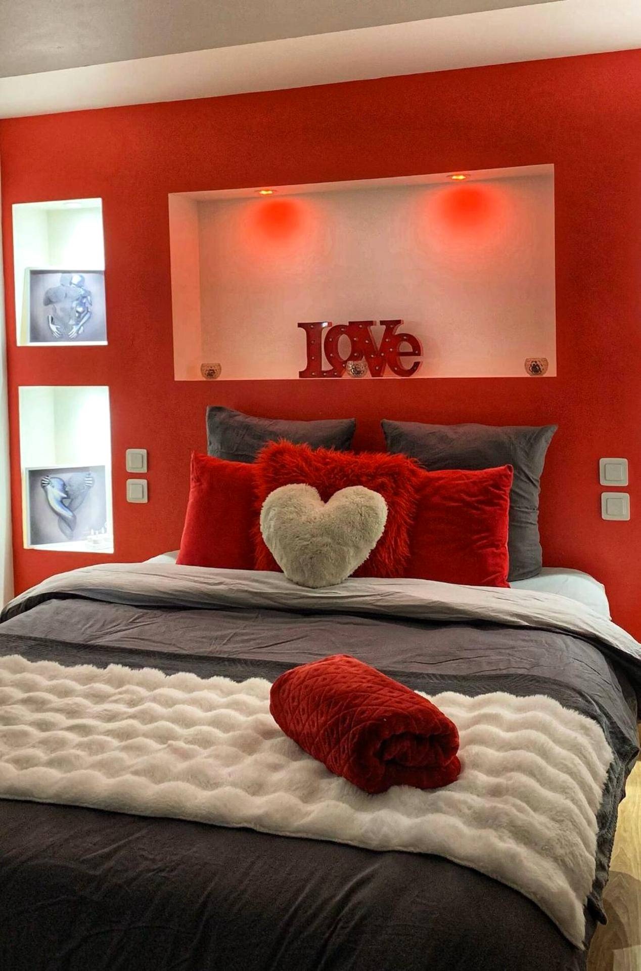 Lit avec coussins cœurs et décoration rouge - Love Room Perpignan Jacuzzi & Ambiance romantique